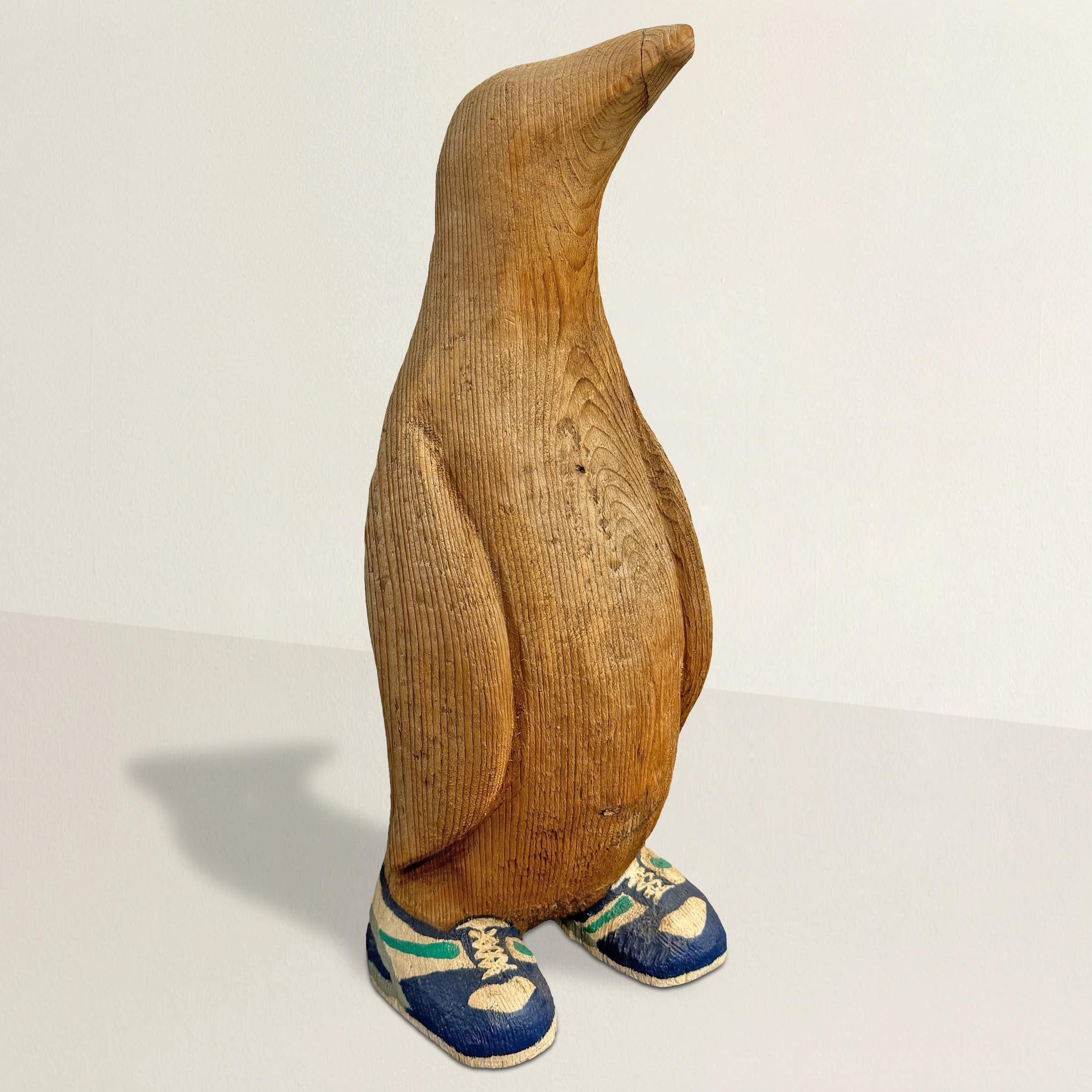 Meet this delightful American Folk Art hand-carved pine penguin sporting a pair of painted Nike shoes! With a whimsical tilt of his head, he exudes an endearing charm, as if pondering the mysteries of the world around him. His wings tucked snugly by