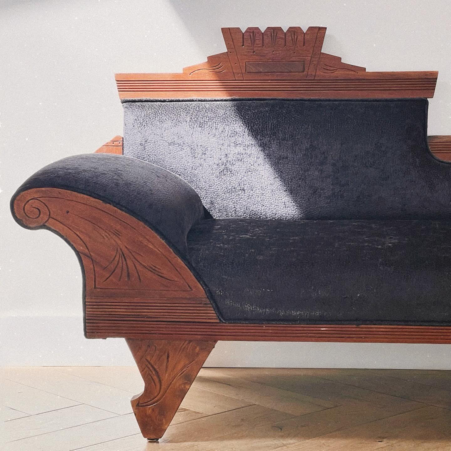 A craftsman pre-war folk art chaise longue, early 20th century. Hand-carved oak and pewter-toned textured fabric, genre Frank Lloyd Wright after the Arts & Crafts movement saw the return of Art Nouveau sensibilities; note the vaguely floral carving