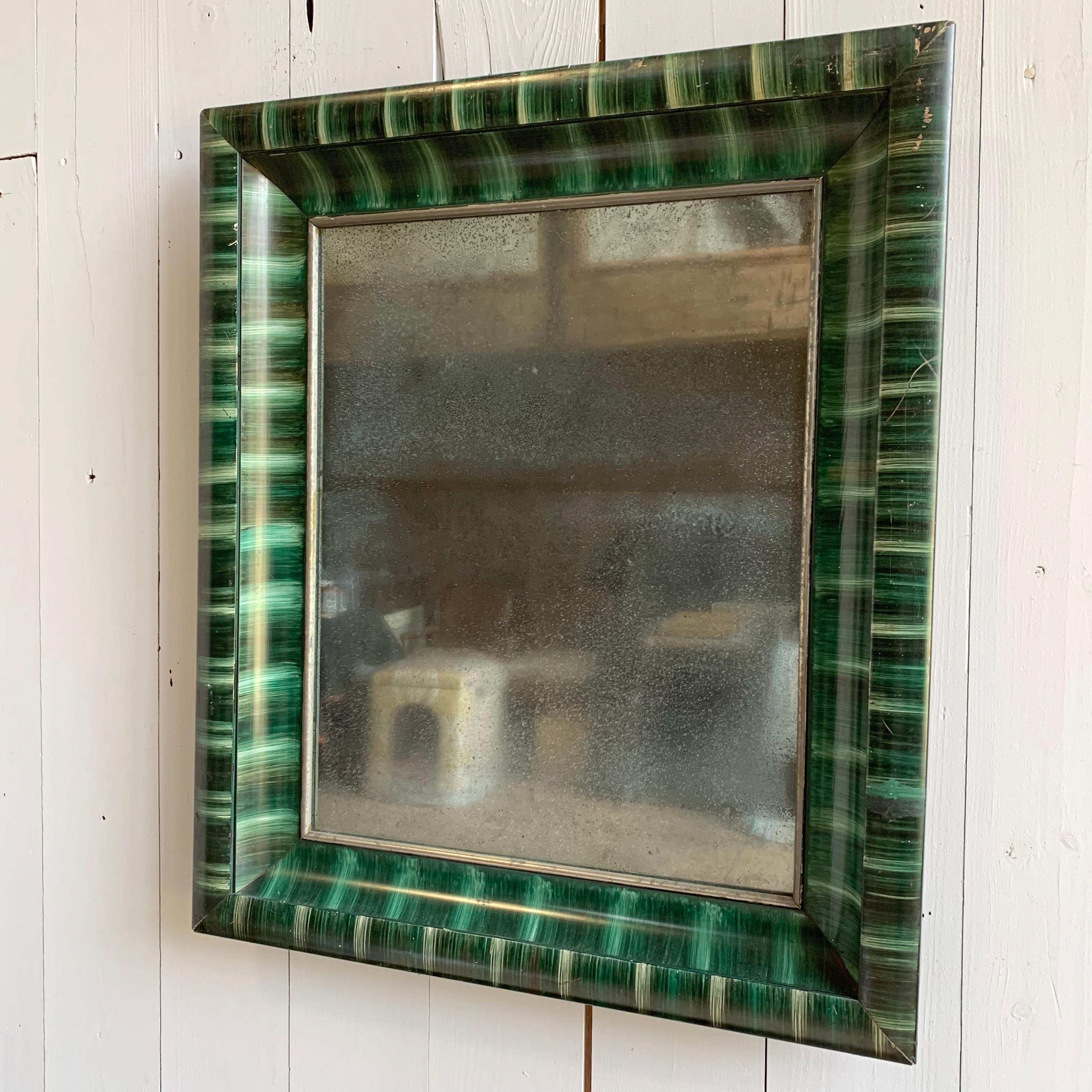 A charming faux malachite framed mirror in the folk art manner, circa 1900, France.