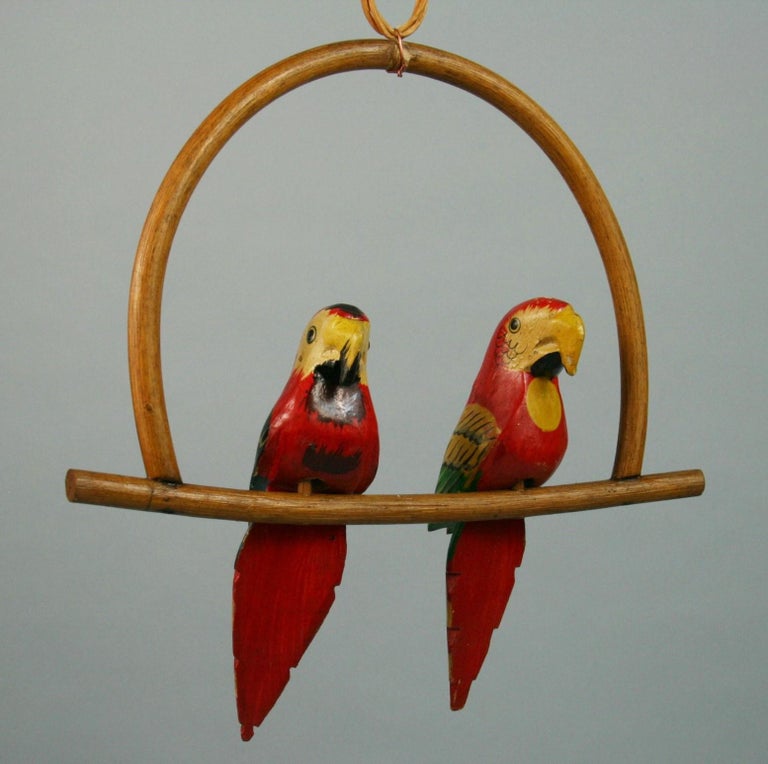 3-528 pair hand carved and painted red parrots on a swing
Supplied with 3 feet of wicker chain
Dimensions are from top of swing to bottom of tail.