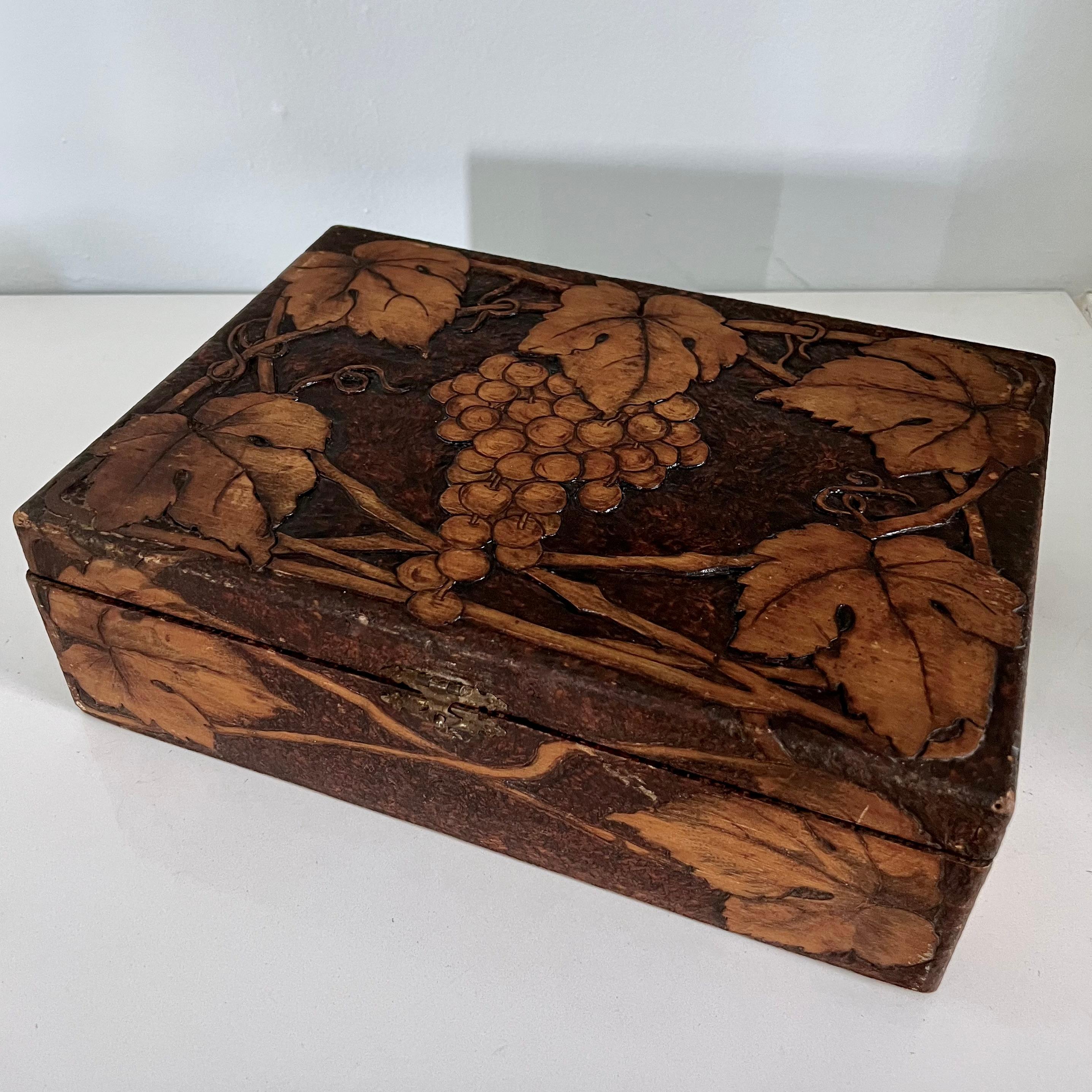 Impresionante caja de madera tallada a mano con detalles de uvas, vides y hojas. 

Esta caja de madera maciza dionisíaca es un complemento para cualquier cocina, ideal para tarjetas de recetas o bolsitas de té. También se puede utilizar para