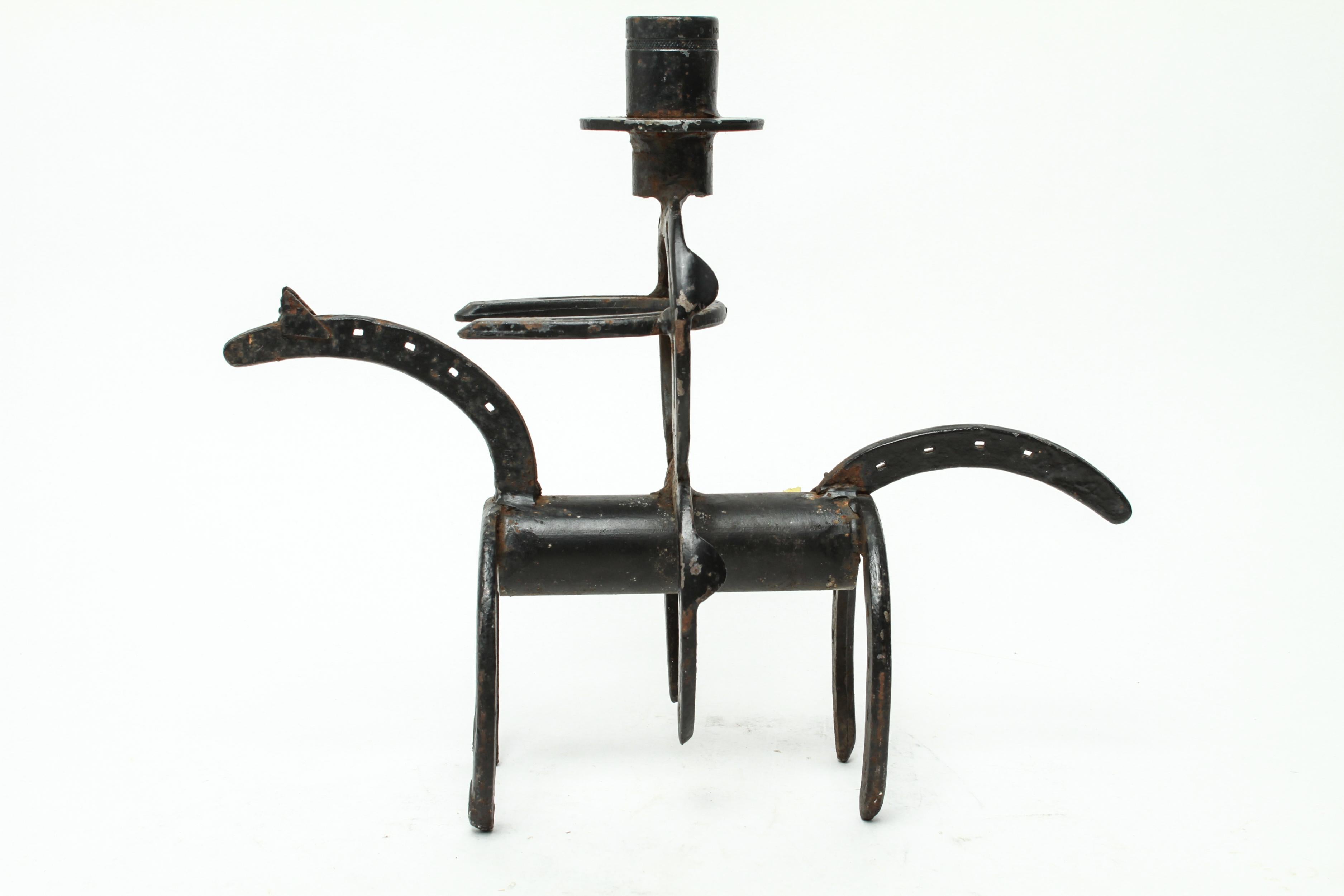Folk Art welded sculpture in horseshoe iron in the shape of a man riding a horse. The piece is in great vintage condition with minor age-appropriate wear.