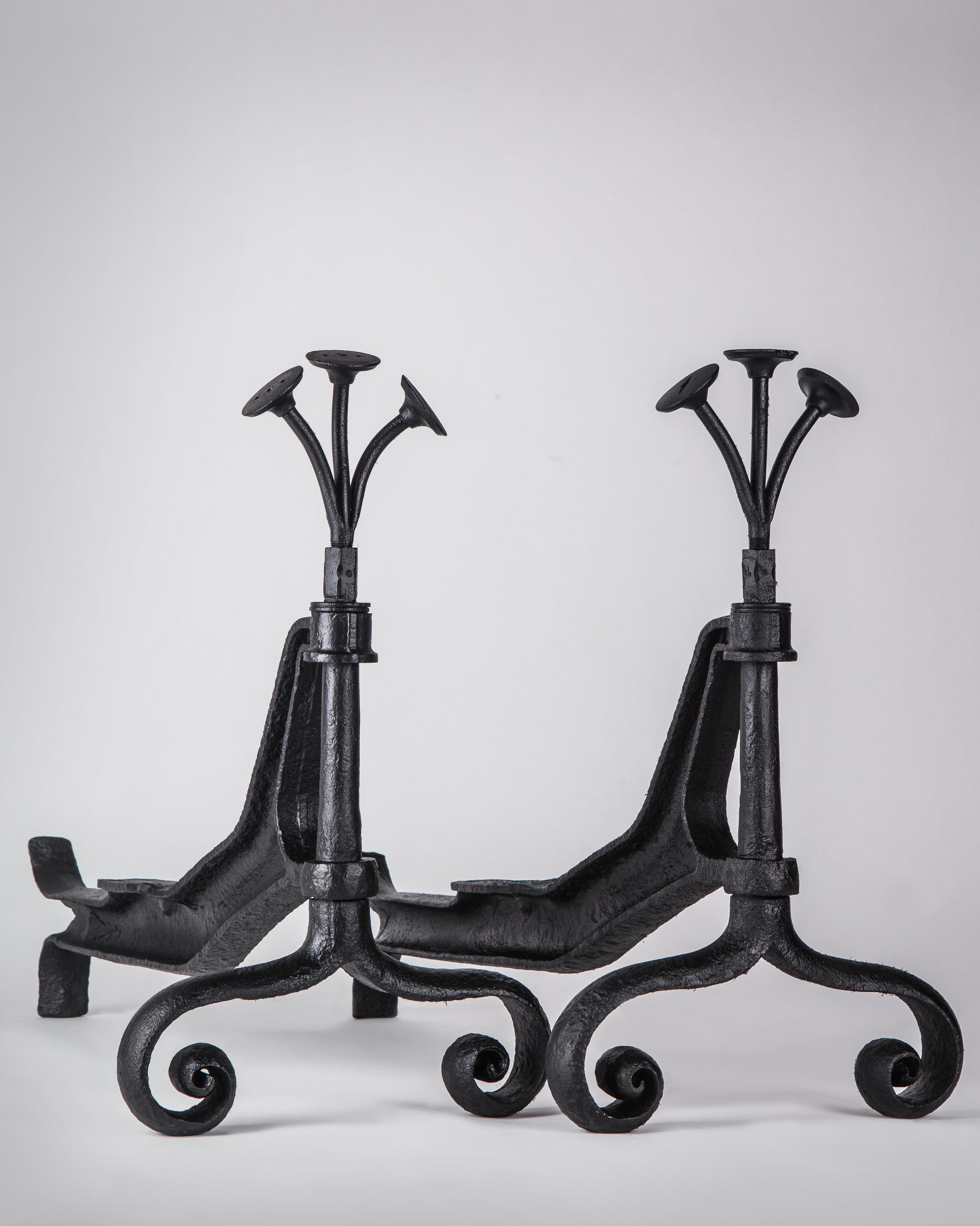 AFP0598
A pair of vintage andirons, made in the folk art style with truck axles, topped with a bouquet of engine valve stems and terminating in scrolled feet. The iron in a blackened finish. Circa 1940s.

Dimensions:
Overall: 18