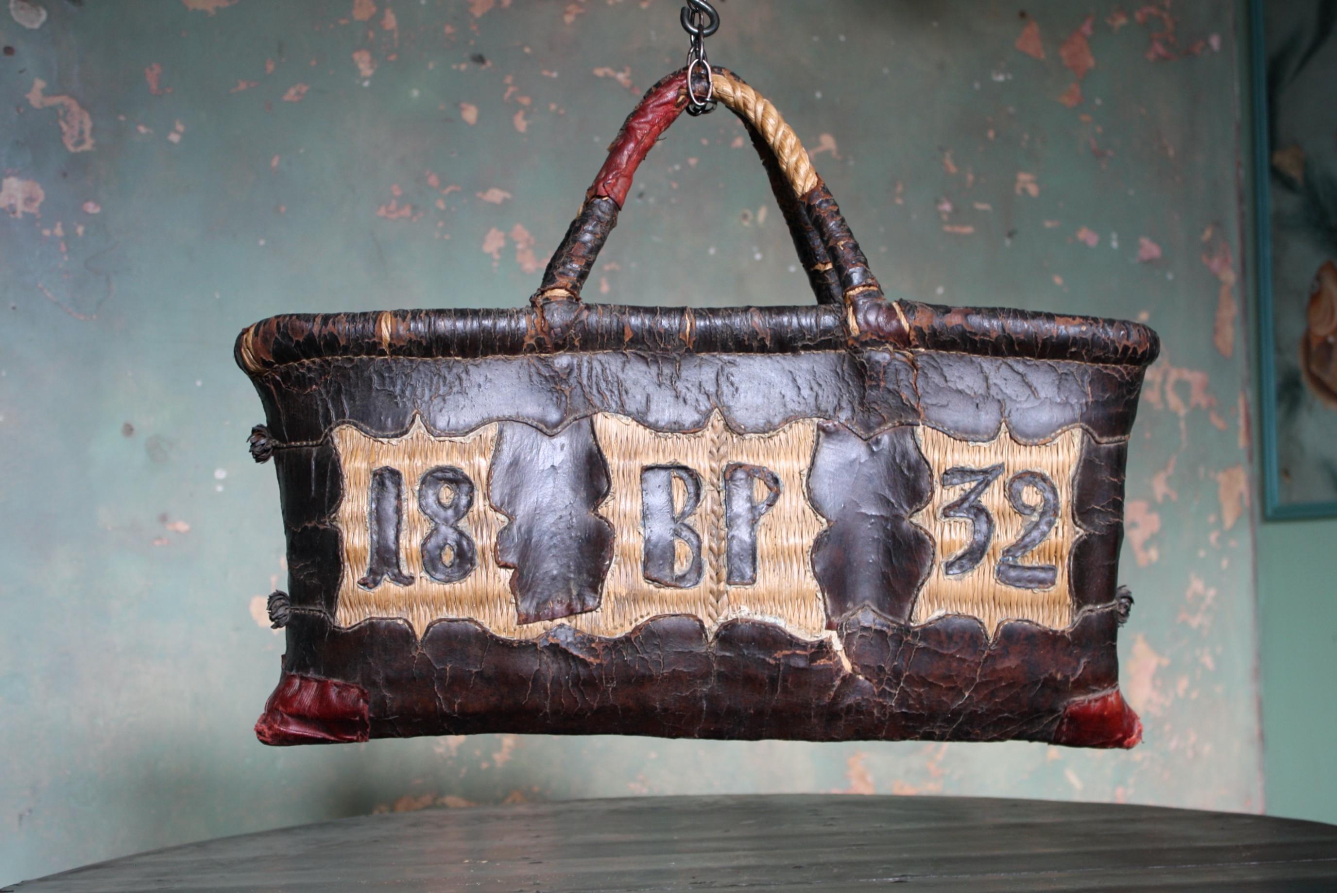 A charming woven rush bag, with applied leather sections, initials and the date 1832, the reversed also has appliqué leather sections of organic flowing forms 

The piece is in good condition considering its age and purpose, by repute a butchers