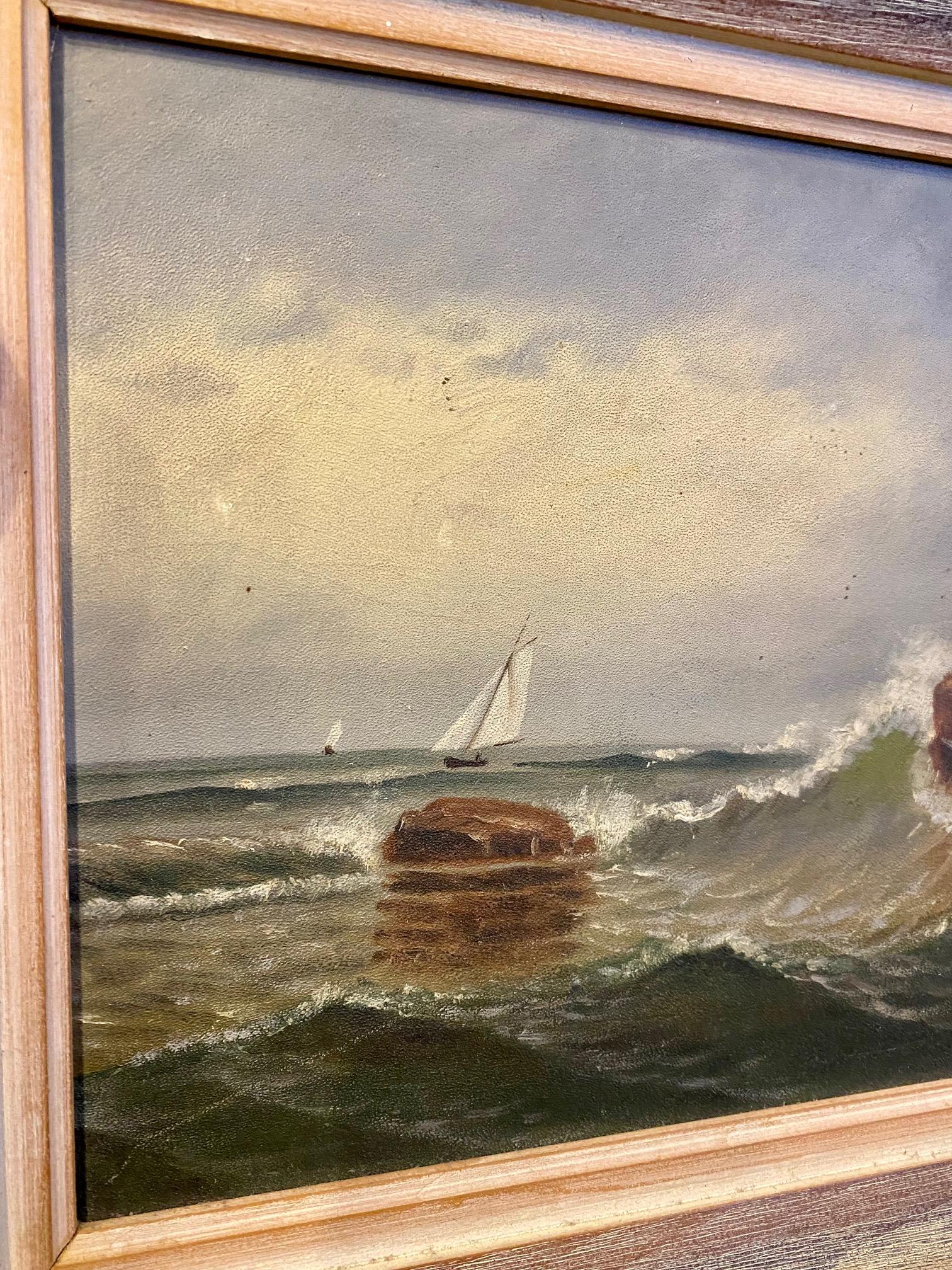 Antique Folk Art Maine rocky coast seascape, by D. A. Fisher (1867 - 1940), circa 1900, an oil on board seascape with gentle combers breaking on rocks on the foreground, with two sloops sailing in the background, signed lower right. The reverse