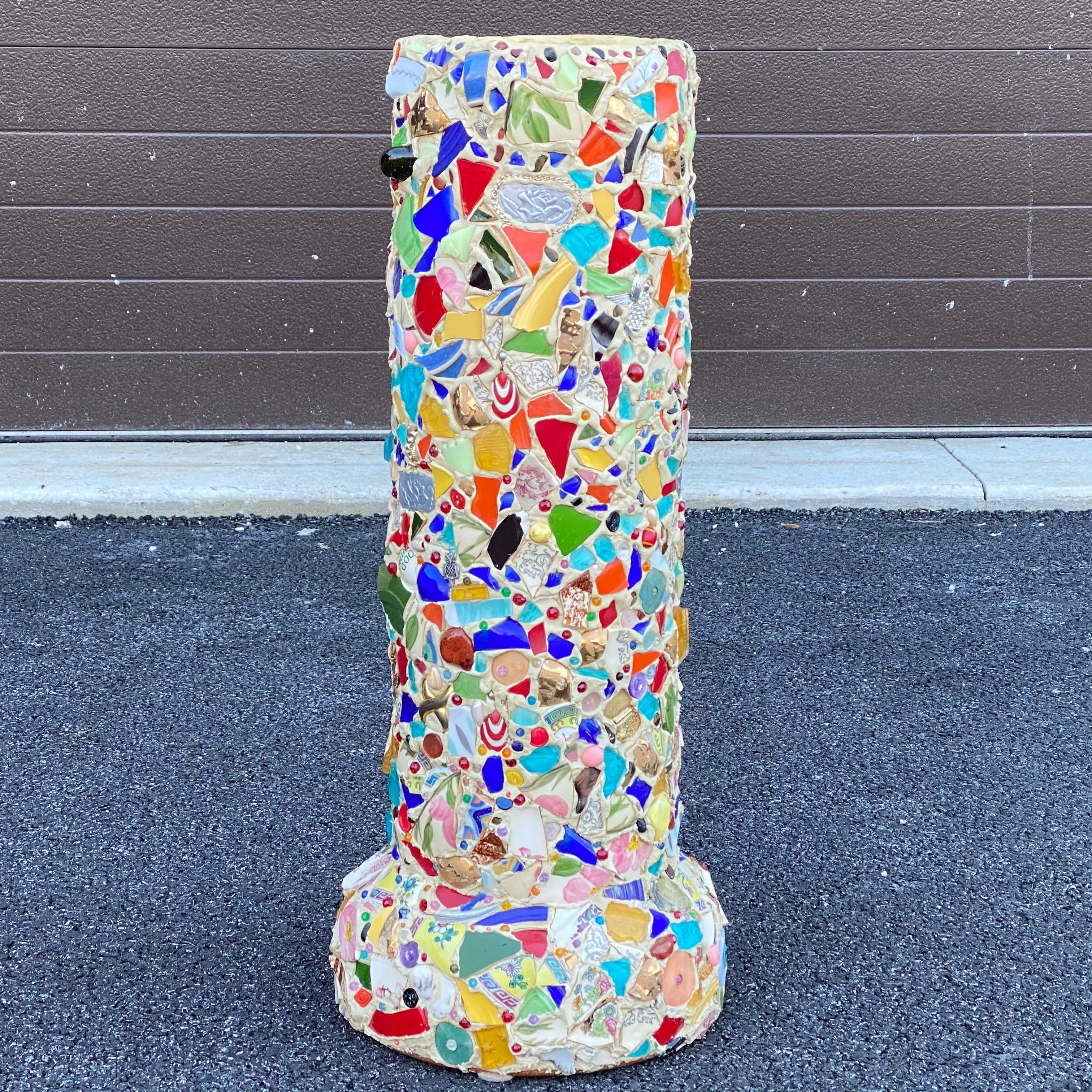 Un mosaico único de arte popular hecho a mano sobre tubo de terracota que puede utilizarse como paragüero, bastonero o jarrón de suelo. El mosaico está formado por objetos encontrados o recuerdos, como cerámica, vidrio, metal, joyas, etc. La parte