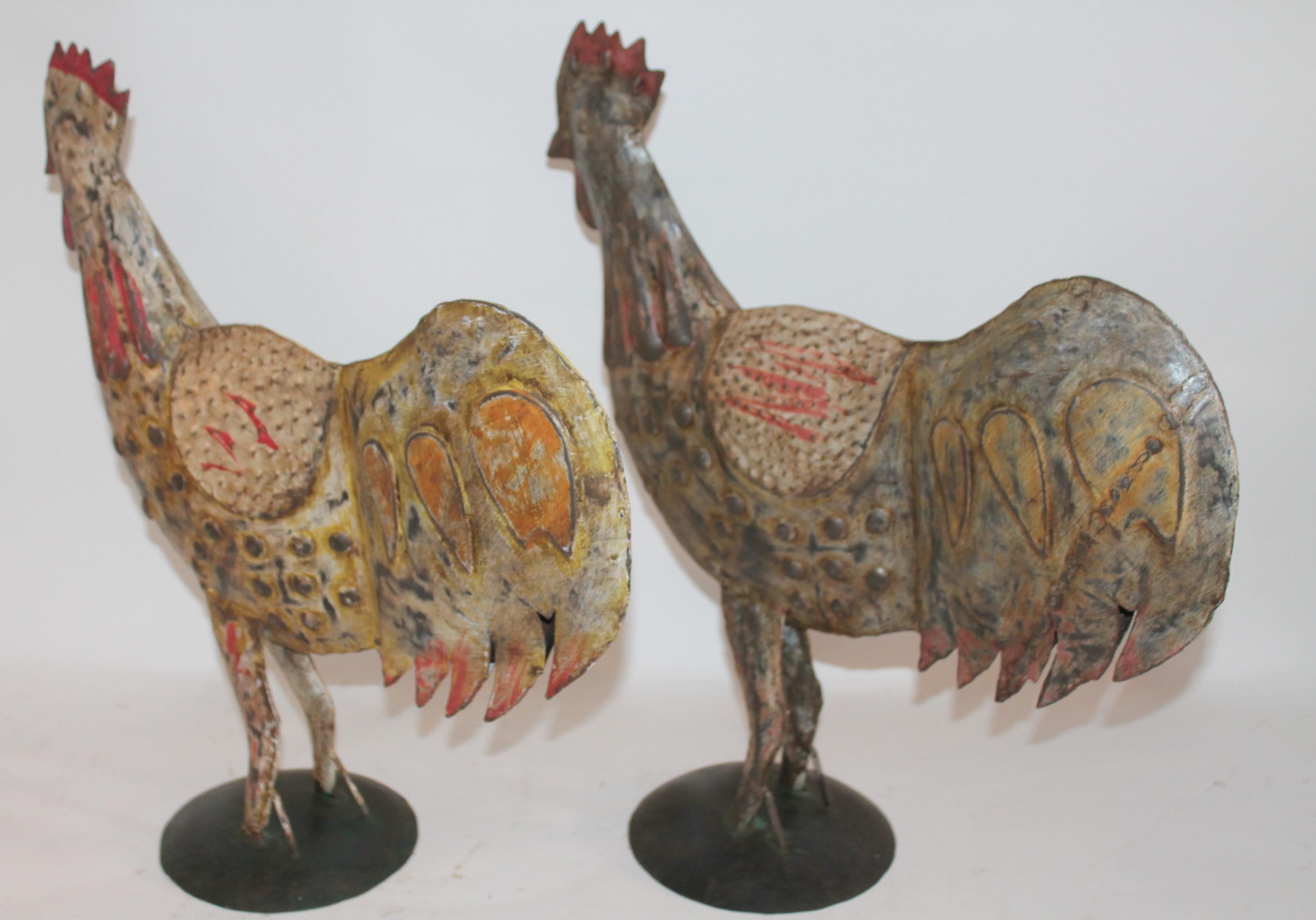 These folky tin painted roosters were originally from Mexico and used in the garden or farm as decorative objects. The painted surfaces are amazing. Sold as a pair.