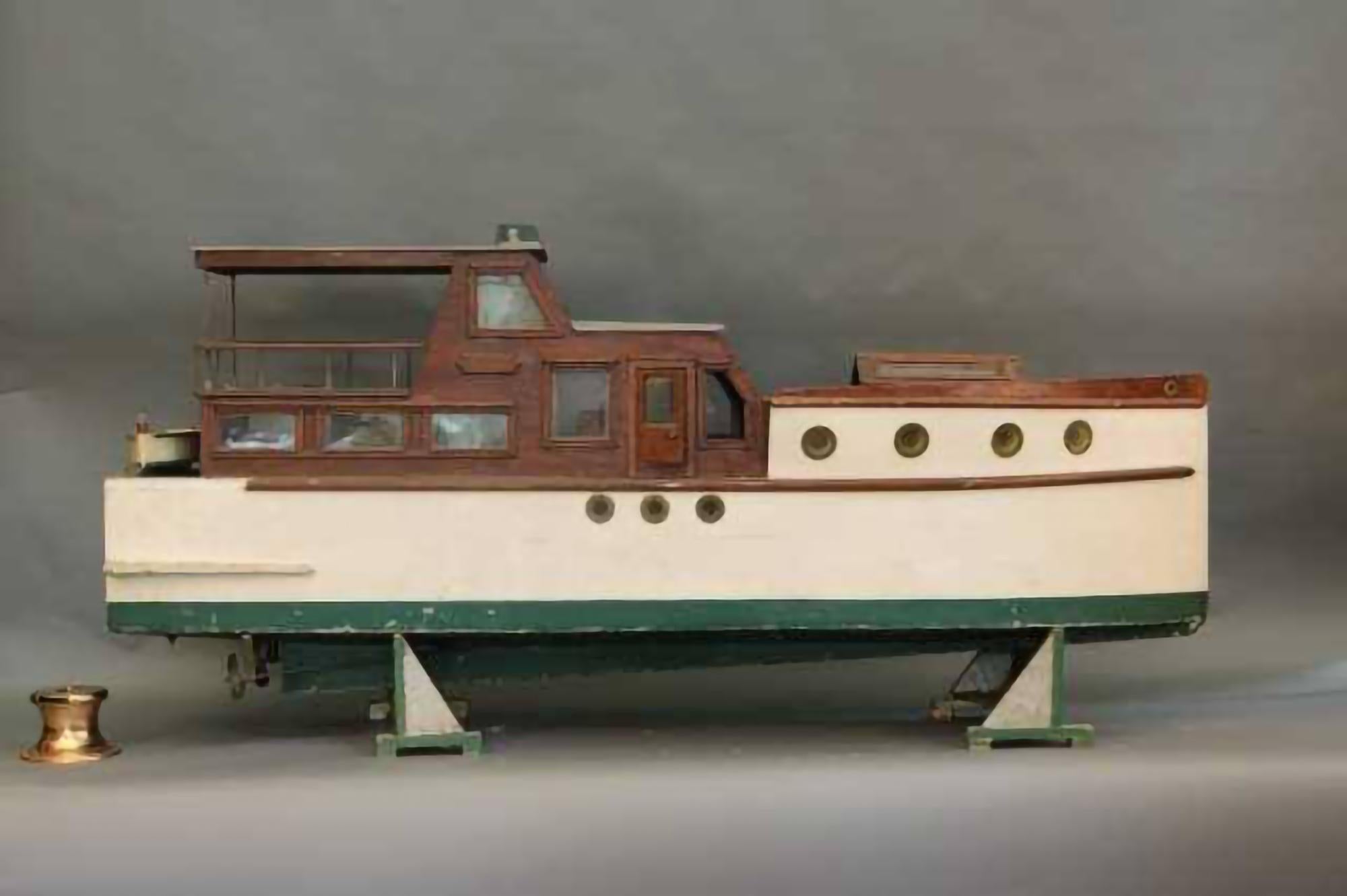 Funky cabin cruiser yacht of a very large scale. Coque verte et blanche avec de grands hublots. Fenêtres en verre et puits de lumière. Cabines en acajou. Sur le tableau d'affichage, on peut lire 