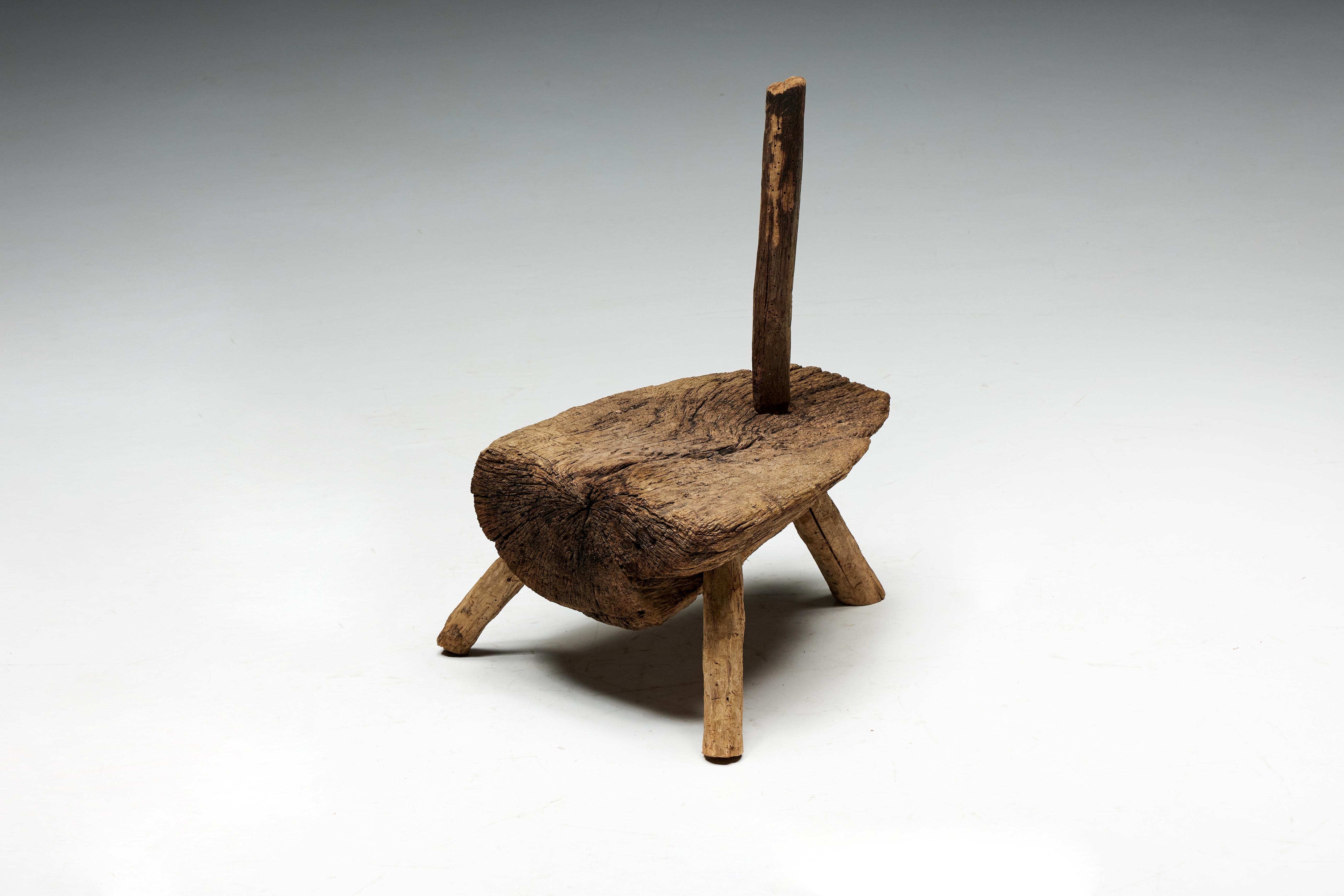 Dreibeiniger Herdstuhl der Volkskunst, ein fesselndes Stück aus der Auvergne des 19. Jahrhunderts, Frankreich. Dieser einzigartige Stuhl vereint nahtlos die Funktionen eines Beistellstuhls und eines Mittelpunkts in der Nähe des Kamins und verkörpert