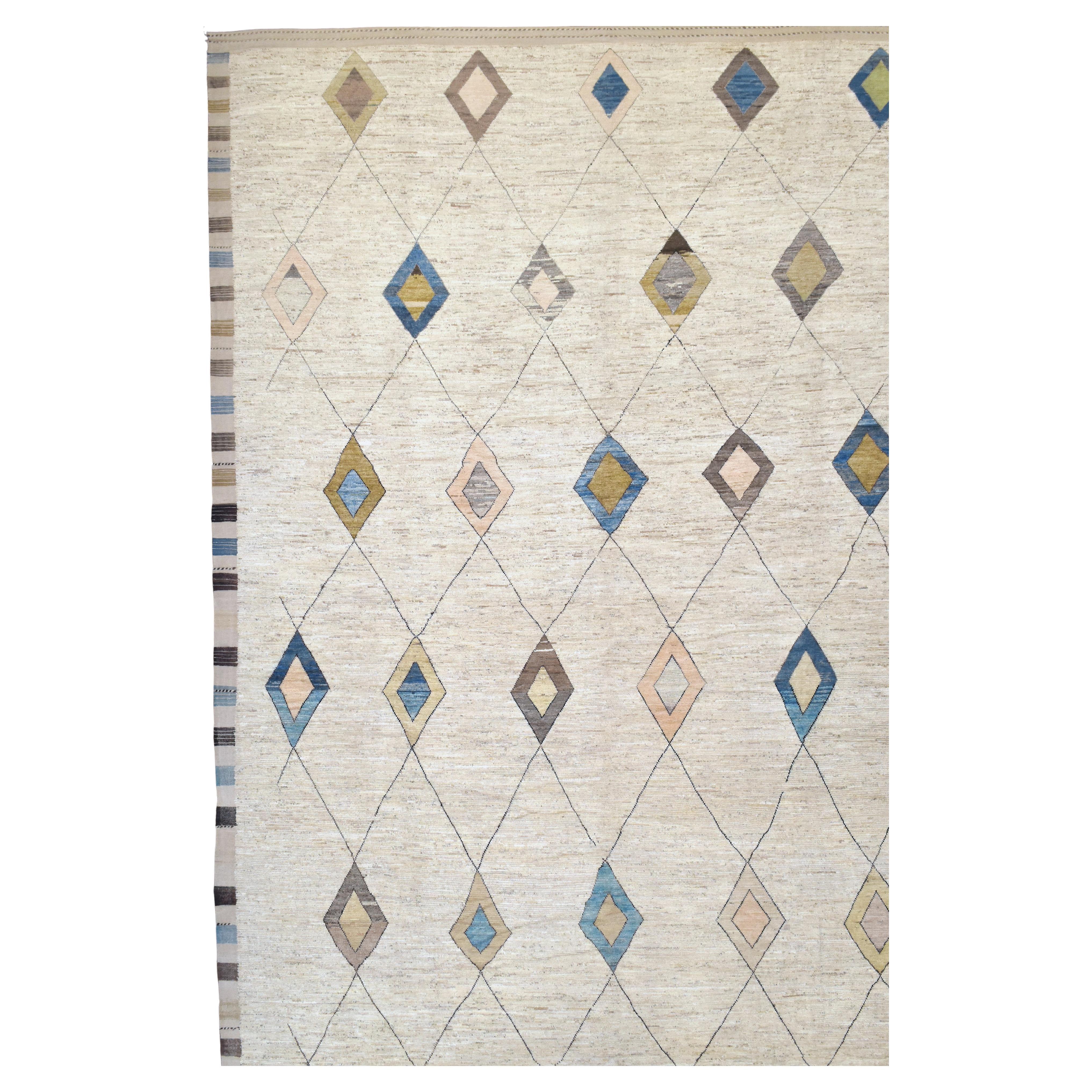 This exquisite hand-knotted wool rug features a modern take on traditional tribal patterns, blending geometric diamond motifs with a natural, neutral-toned background. The soft ivory base is adorned with multicolored diamonds in earthy hues of blue,