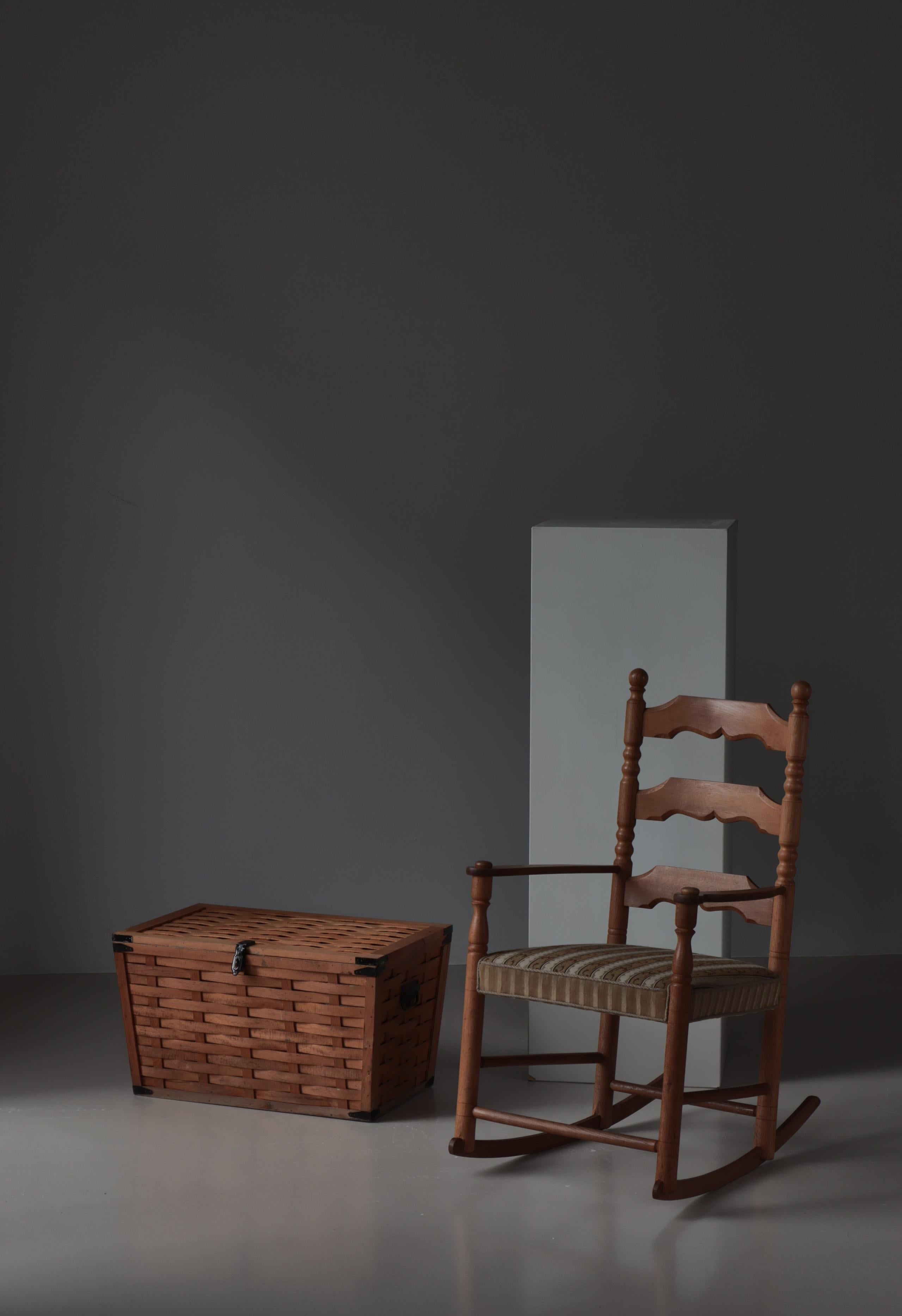 Wonderful rocking chair in solid oakwood by Danish Cabinetmaker Hans Dau (1871-1956). Original embroidered fabric upholstery the seat.
Hans Dau was a renowned master carpenter who had his own workshop in the town of Ribe in Jutland in the first half
