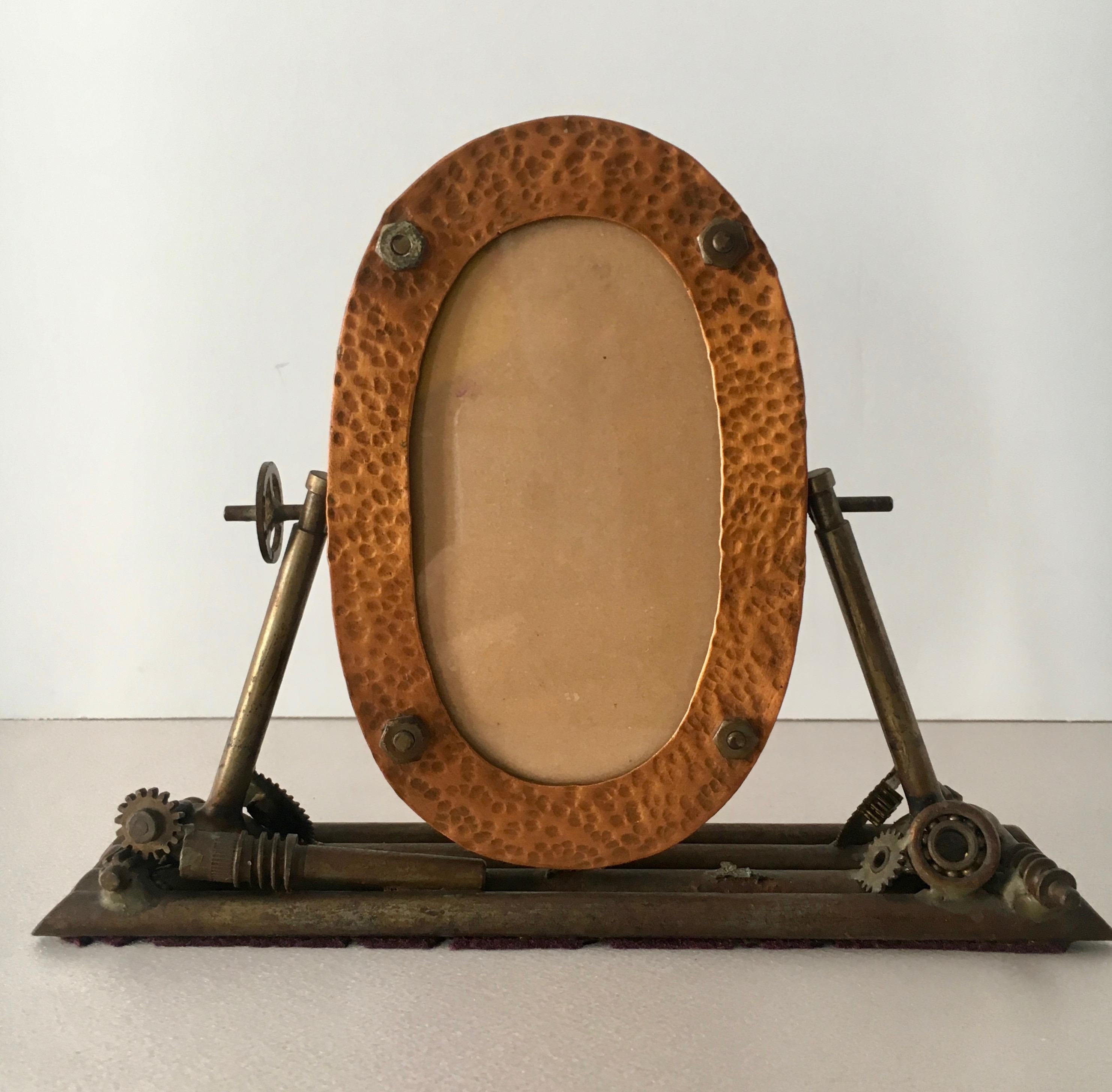 Folk Art hammered copper picture frame, signed 1934. A handsome and unique oval frame with welded machine pieces to form and display the picture frame.
4'x2