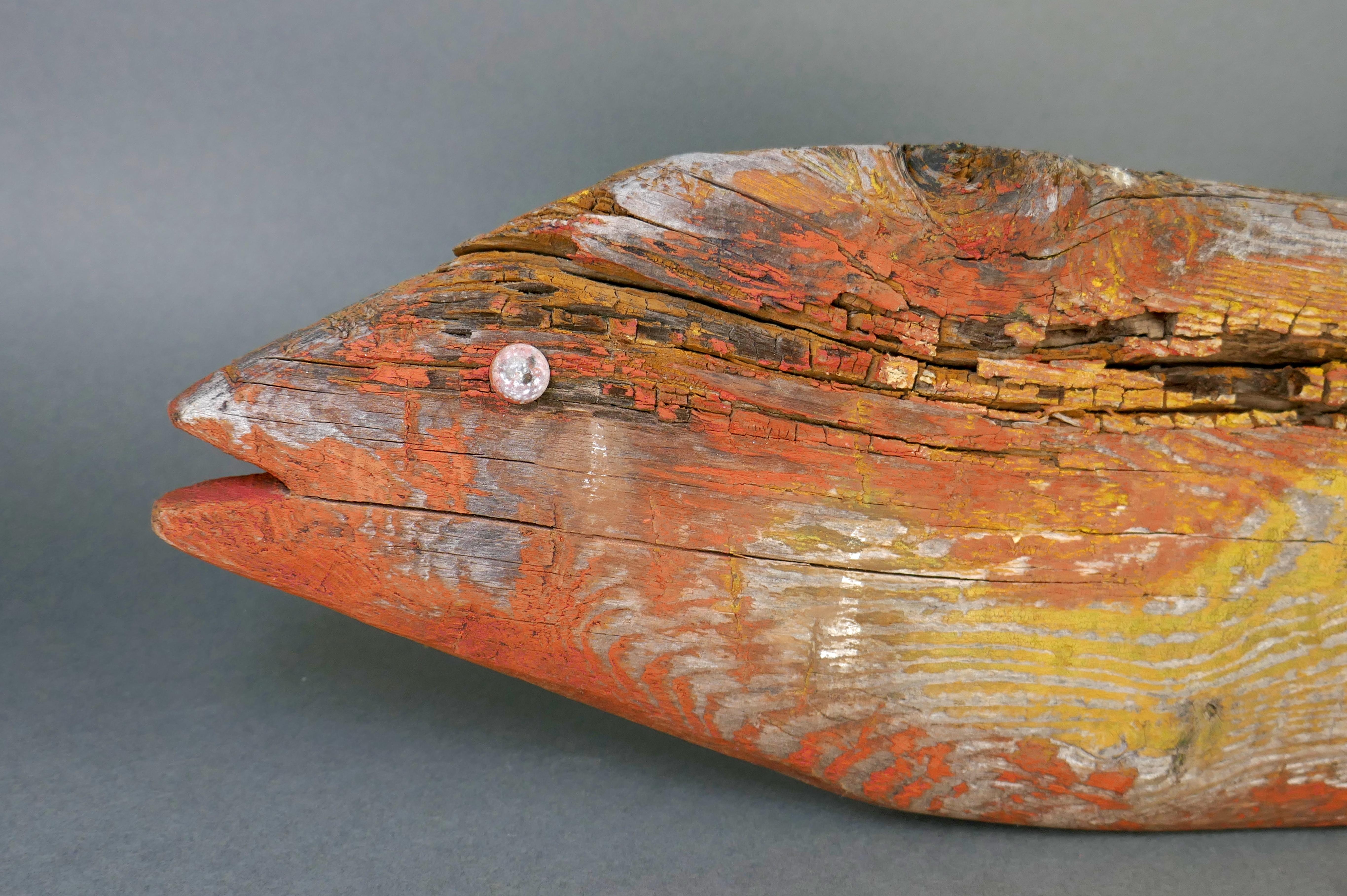 Poisson saumon en pin fortement patiné avec des restes de peinture. Cette pièce présente un ancien trou au centre où elle a été montée en tant qu'enseigne. Il dispose actuellement d'un fil de fer pour être accroché au mur. 