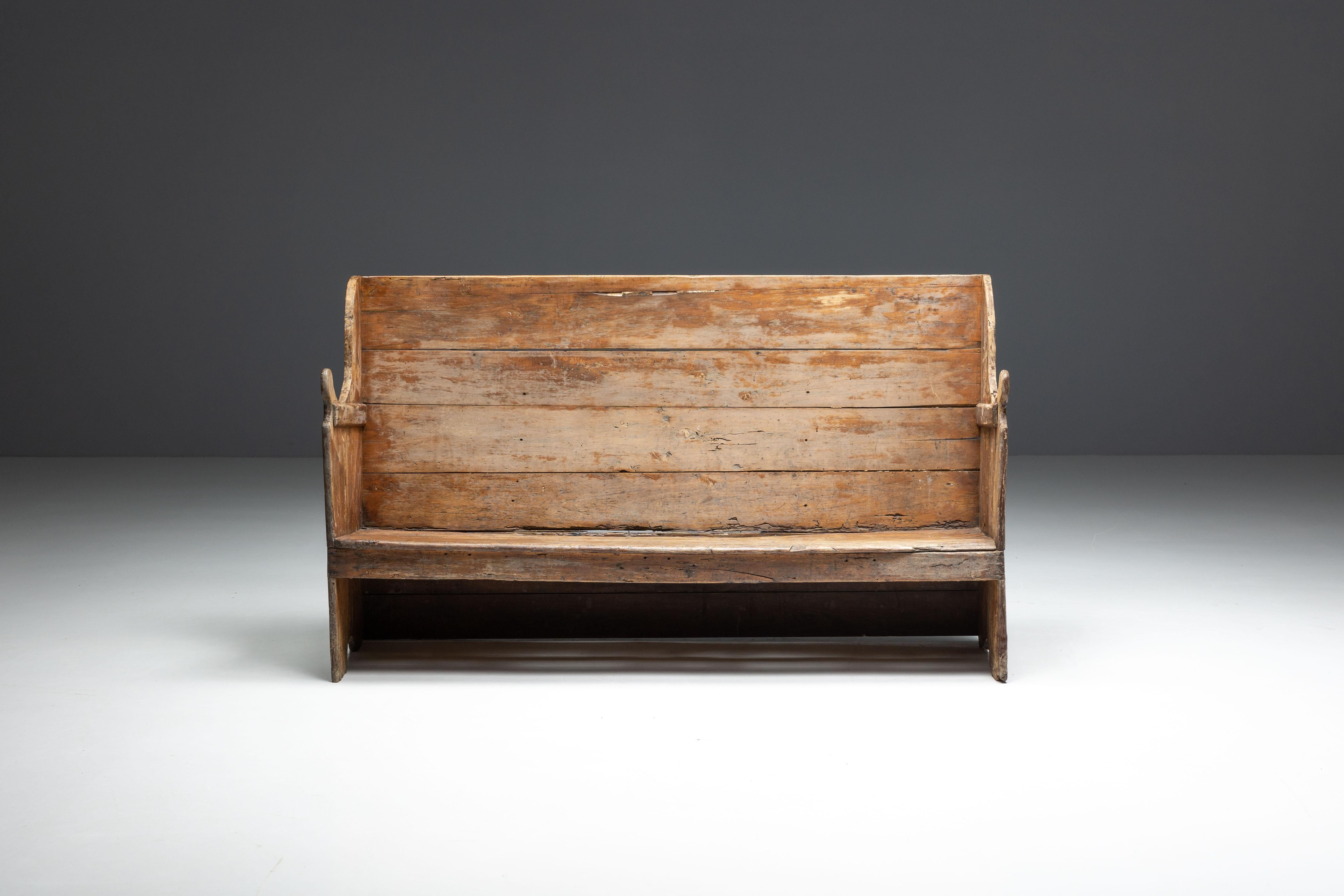 This 19th-century rustic three-seater bench from the Pyrenees features a stunning patina, showcasing its rich history. Its design embodies the wabi-sabi philosophy, which celebrates the beauty of natural imperfections, as it showcases graceful aging