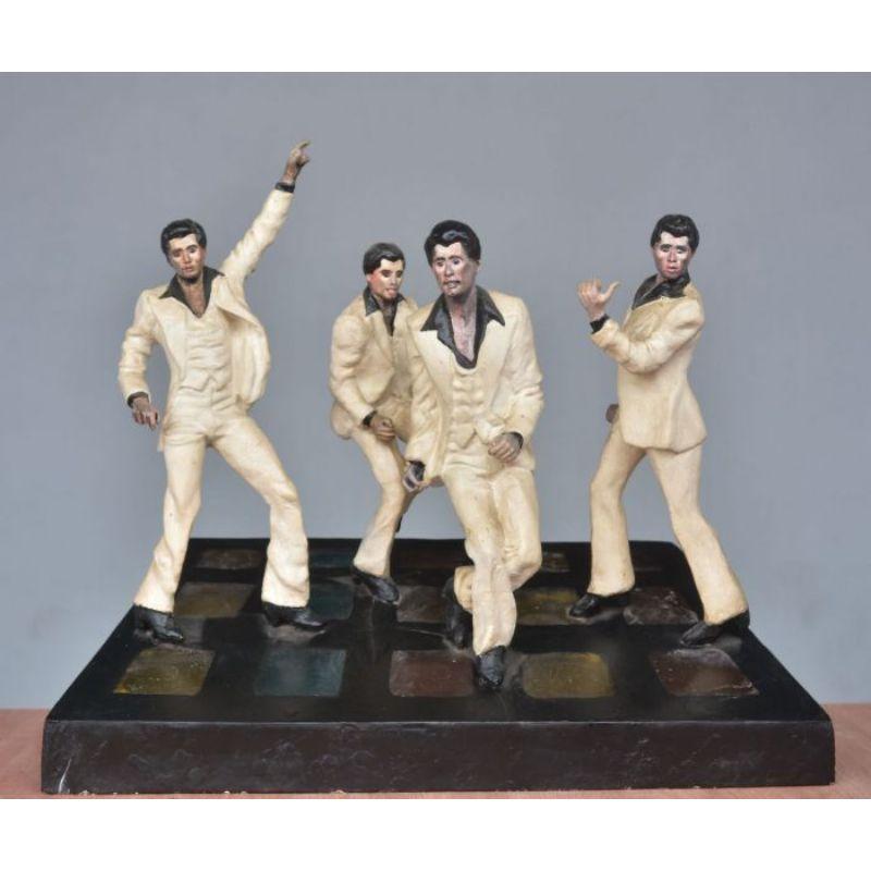 Folk art resin lamp for John Travolta fans representing the dancer in different postures from the film it was a live Adrian Line and dance step lighting below friends and transparent size 58 cm high 65 cm wide and finally 28 cm deep.

Additional