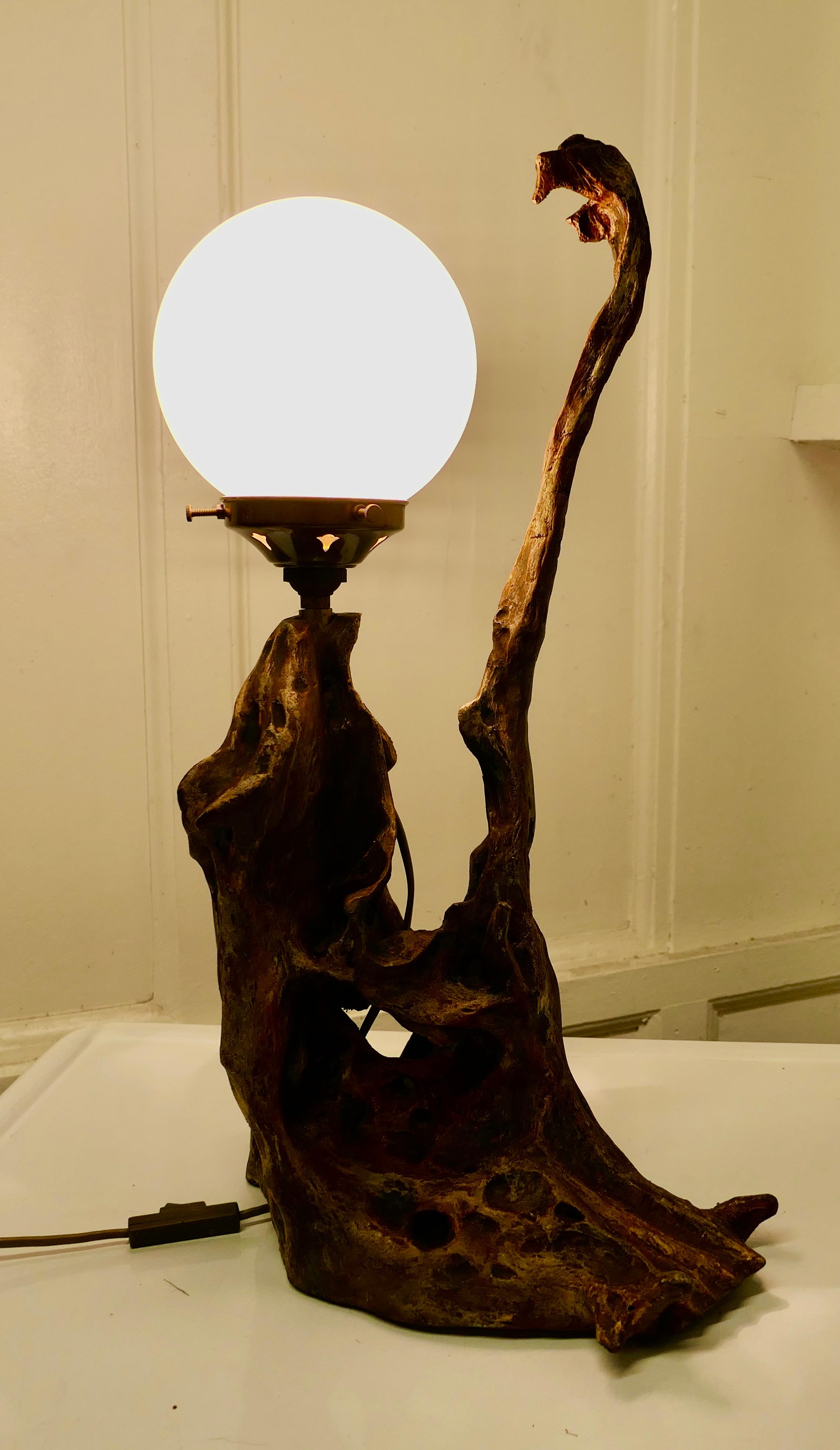 Folk Art root carved table lamp.

This is a very attractive if somewhat unusual piece, it is an old root carving which has been adapted to change it into a charming table lamp, the lamp looks different from every side.
It is very difficult to