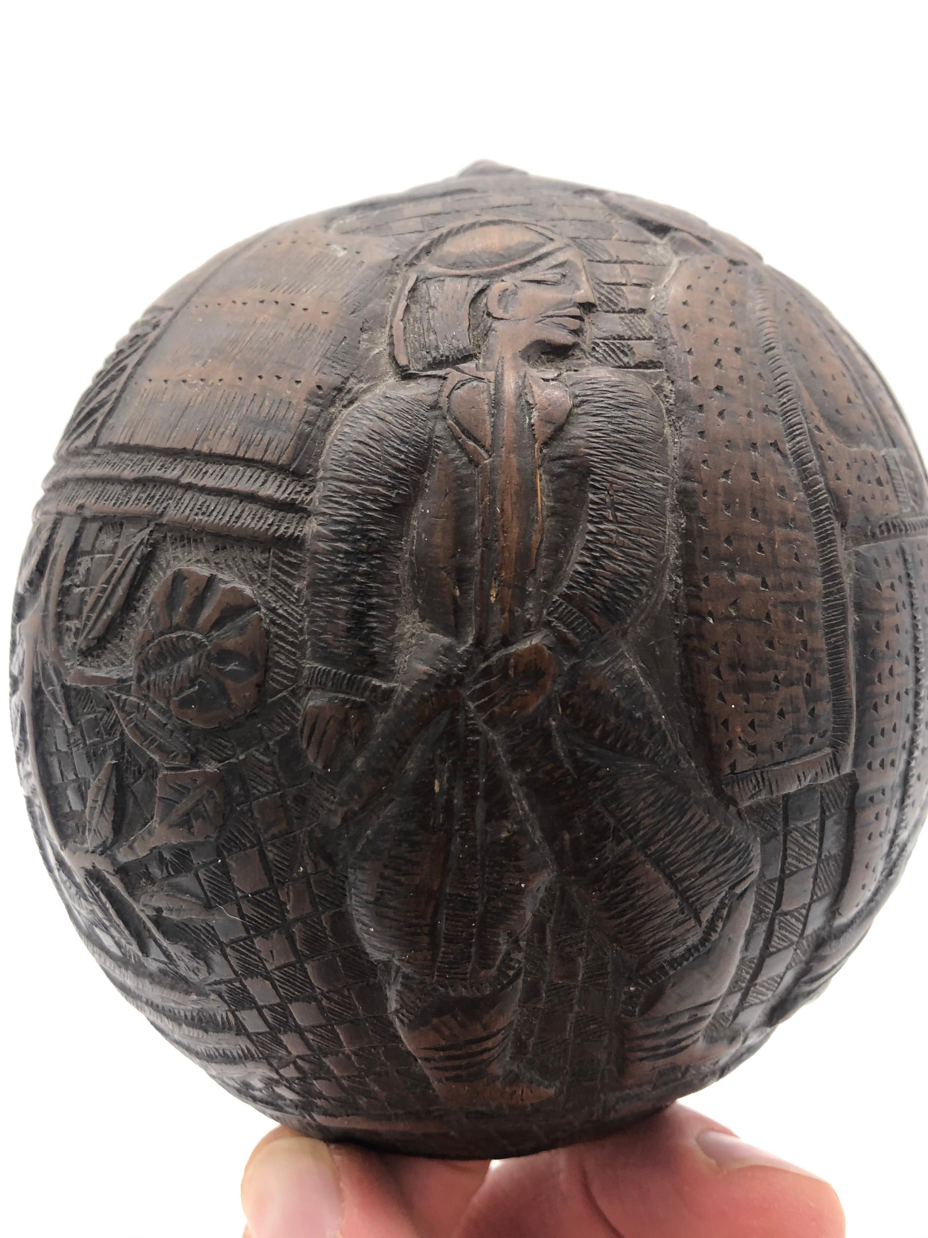 Sailors from various countries would carve green coconuts to help pass the time. This particular example is early and dates to circa 1800. It has some of the most interesting and folky figures, when compared with other examples. There are 3 full