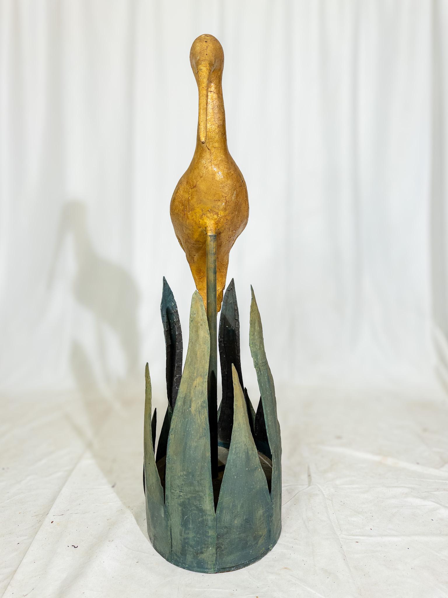 The Folk Art Sculpture of the shore bird is a radiant manifestation of creativity and imagination, blending elements of nature with artistic expression. Crafted as a composite heron, its golden hues shimmer with a timeless allure, capturing the