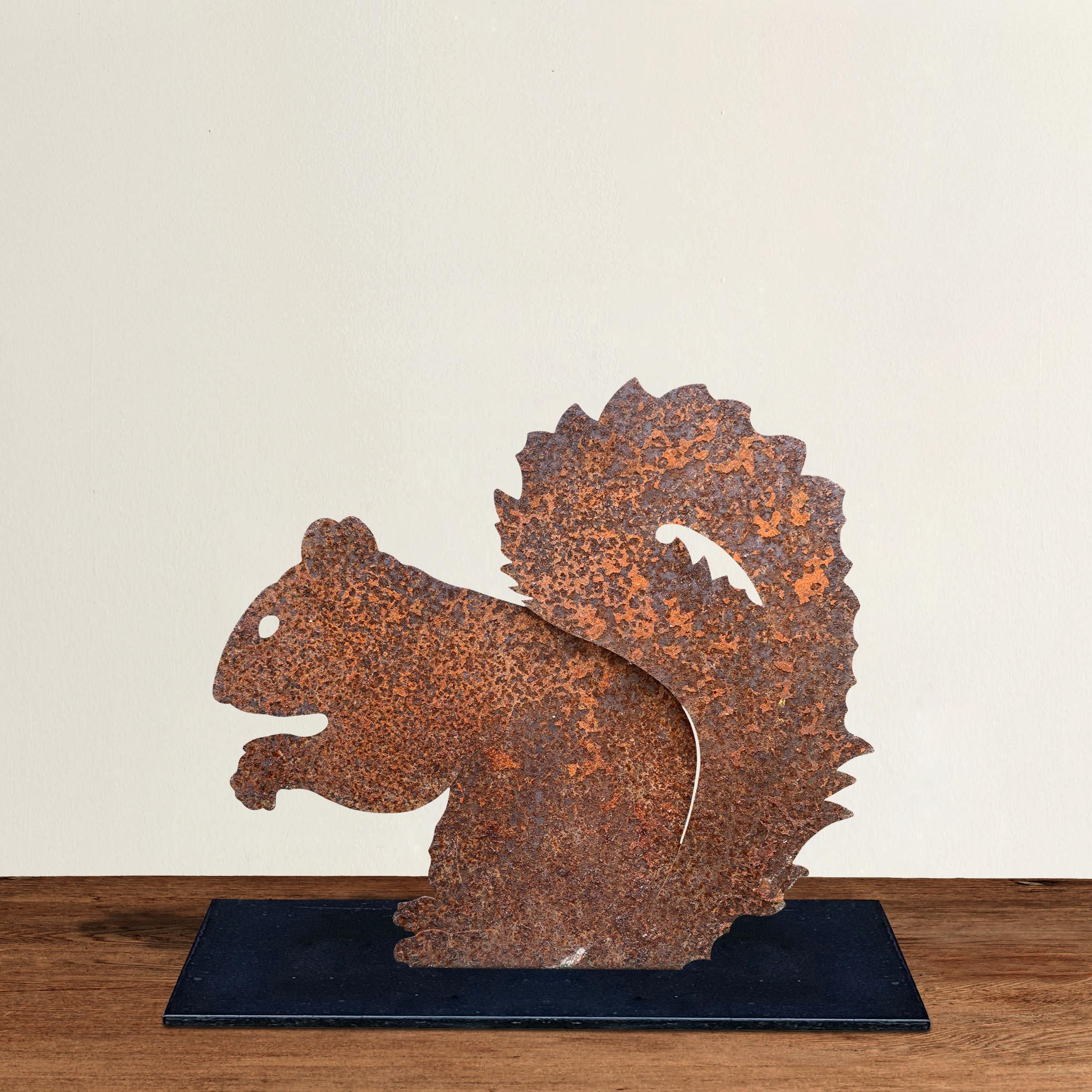 A wonderful and whimsical American folk art seated squirrel sculpture mounted on a custom steel base. Perfect for display indoors or out.