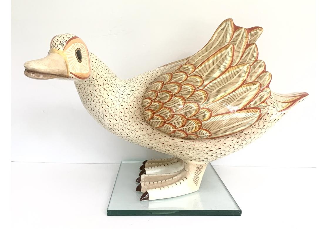 figura de pato de papel maché de colores, de tamaño natural, de arte popular, sobre una base de cristal personalizada. El pato pintado a mano en tonos naranjas y dorados brillantes. Firmado como se muestra.

Dimensiones: 17 1/2