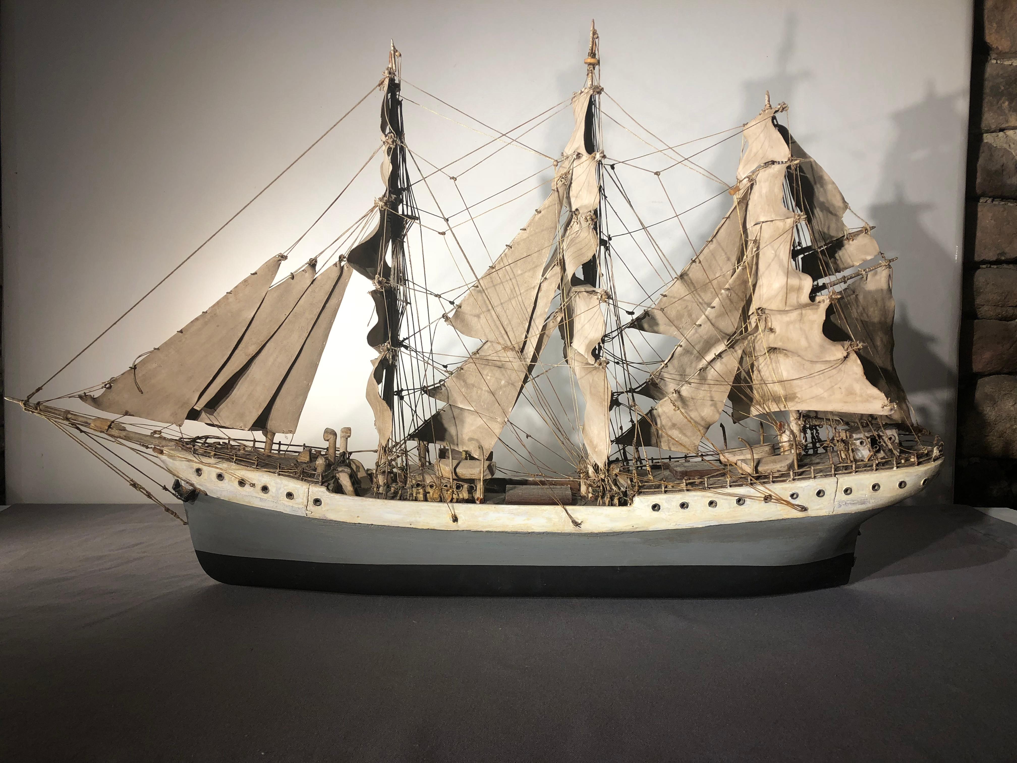 A naive Folk Art ship model in carved wood with fabric sails and elaborate rigging, American, circa 1900.