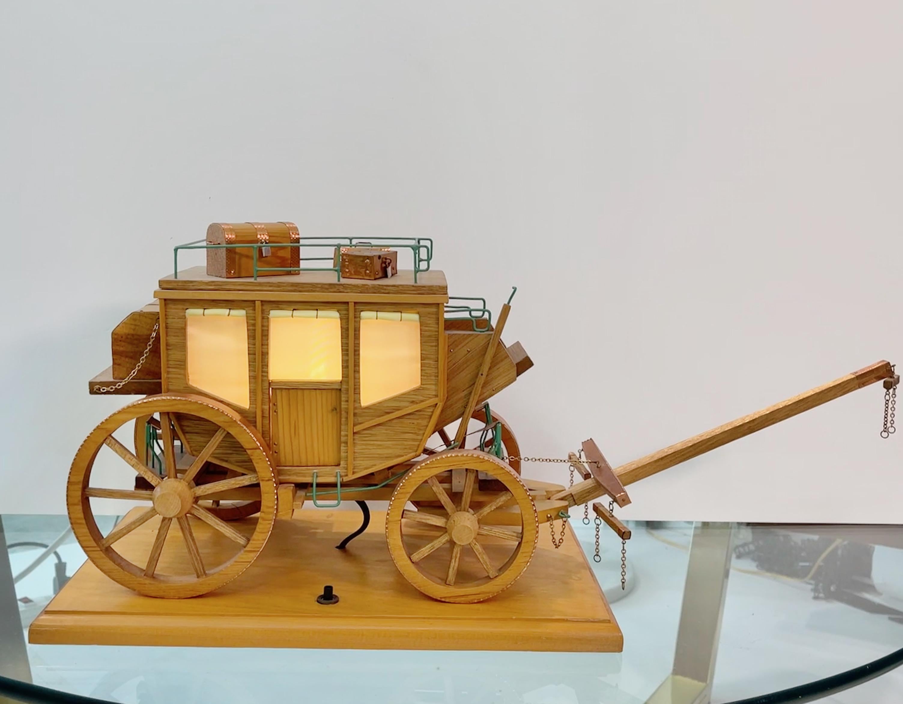 Remarkably well preserved 1950's Folk Art model of a stage coach illuminated from within, complete with working carriage springs and movable yoke and luggage. On/off switch on wooden base. Great nightlight.. Constructed from thin plywood with hand