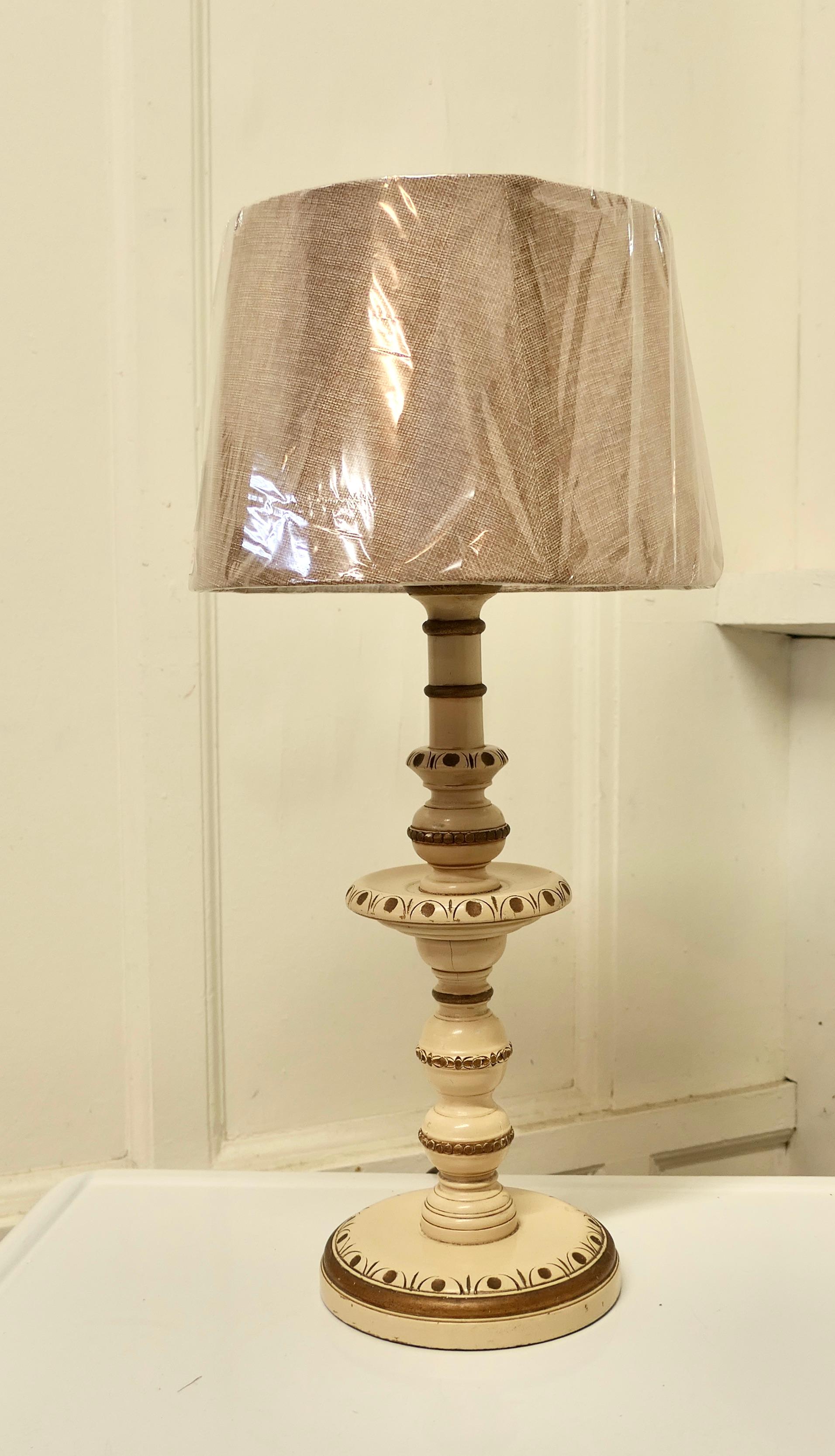 Folk Art Style carved and painted table lamp.

This lamp has a carved decoration painted in cream with gold highlights, the lamp comes with a new coarse linen lamp shade.
The lamp is 25” high with the shade which is 11” in diameter.
THM157.
 
