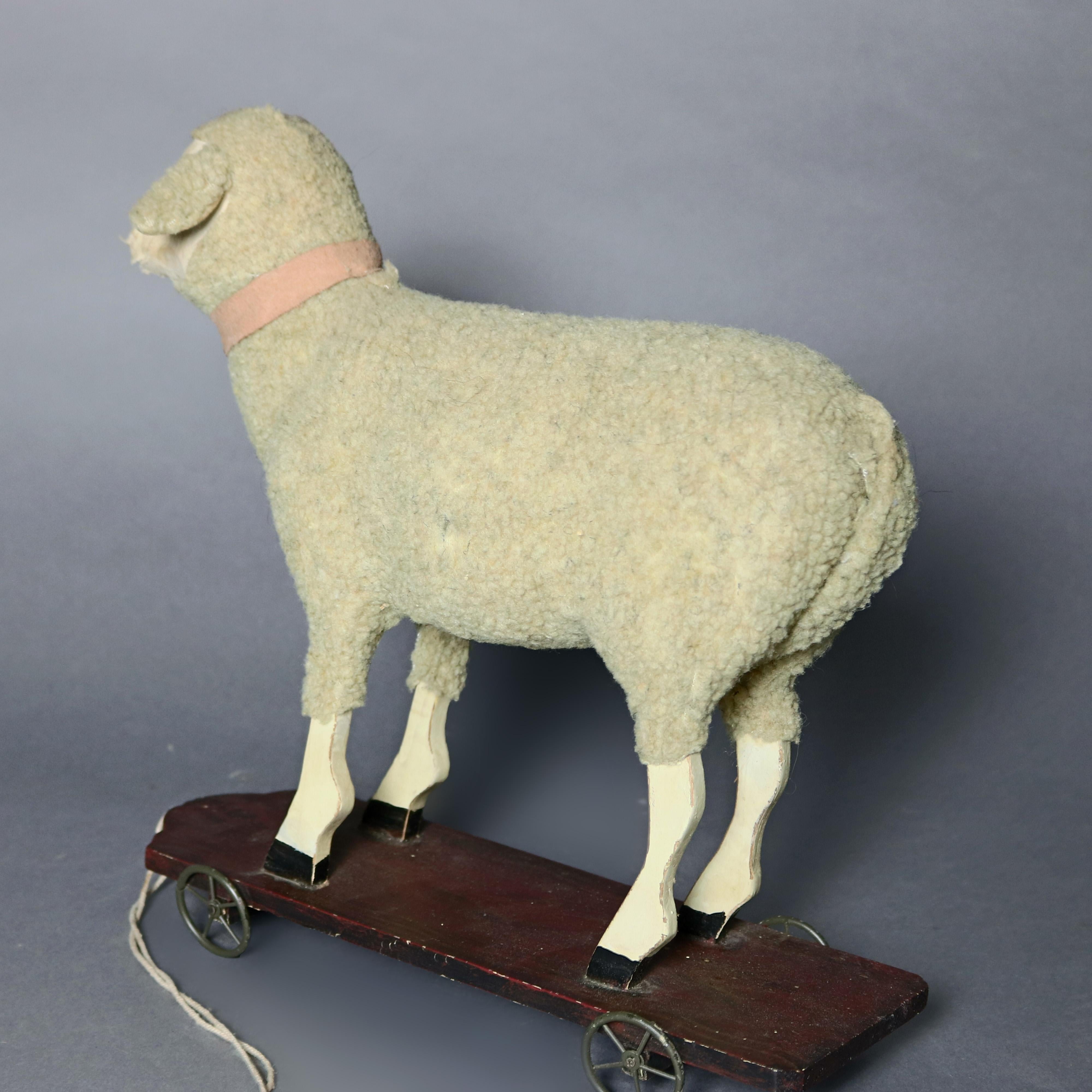 A Folk Art style childs rolling figural pull toy offers cutout sheep form covered in fleece and seated on a wooden base having metal wheels and a pull cord, 20th century

Measures: 13.75