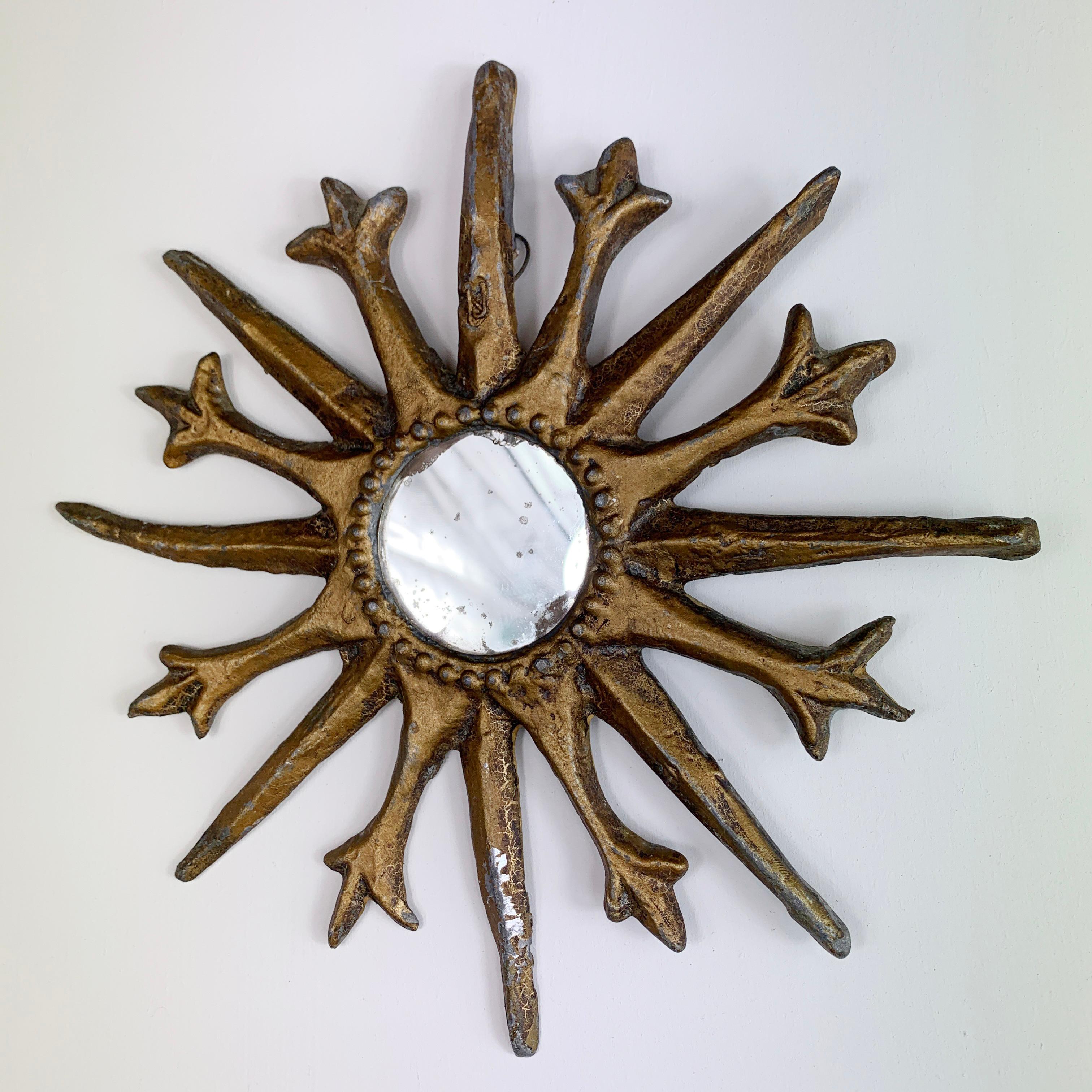 A charming and very rare folk art sunburst mirror, French, dating the the early 1800's, it is formed out of lead which has been hammered and shaped, it has then been overpainted in gold, a small foxed mirror to the centre.

This is a wonderful