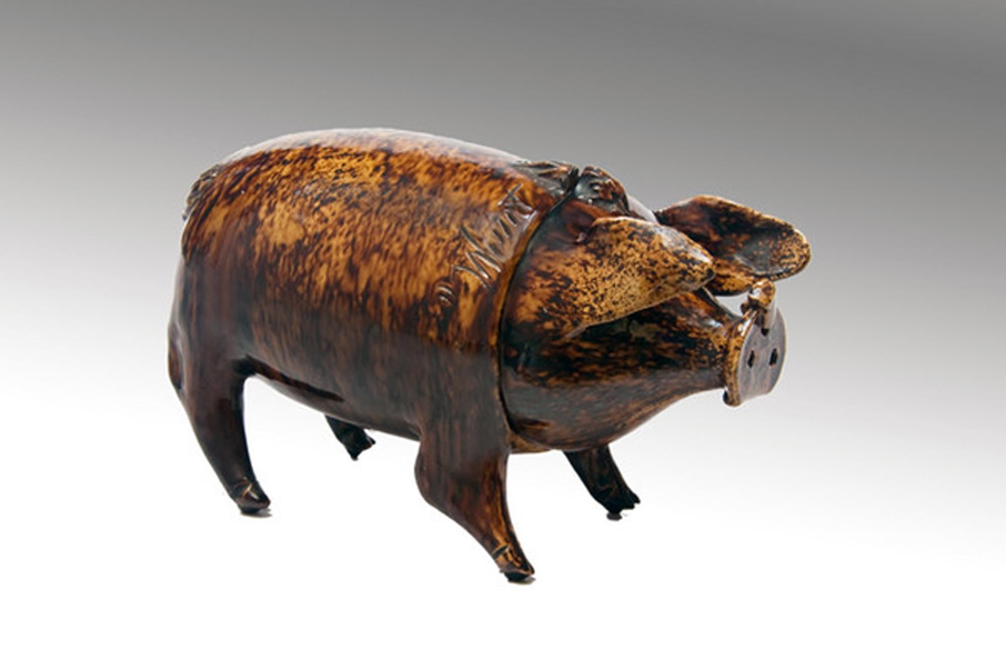 Pichet et tasse à porc en poterie du Sussex Folk Art,
de la poterie Belle-Vue, Rye, Royaume-Uni,
vers 1870.

Ce porc du Sussex de la poterie Belle-Vue Rye est en fait un récipient à boire avec une tête amovible qui peut être utilisée comme une