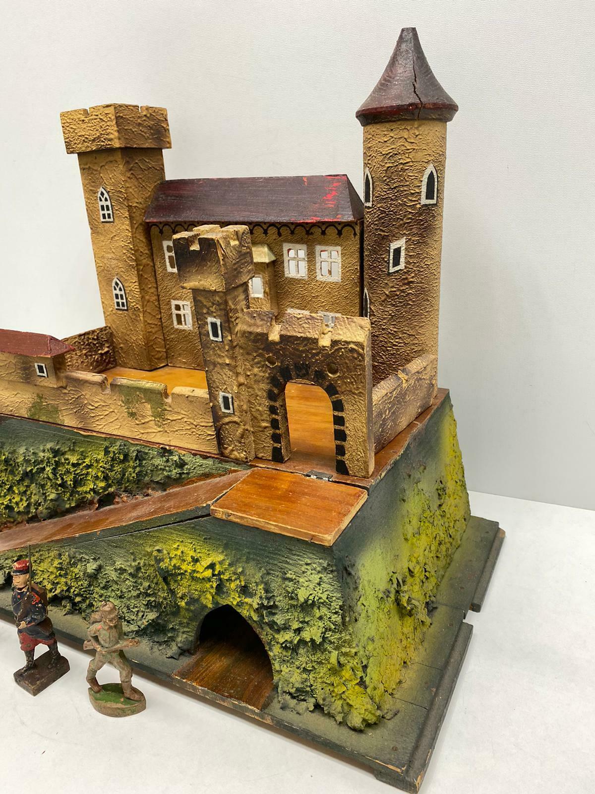 Offered is an absolutely stunning toy castle, it is a beautiful example of early 20th century, German handmade craft. The architectural detailing in the crenellated towers and torches flanking the staircase as well as the hand painted details make