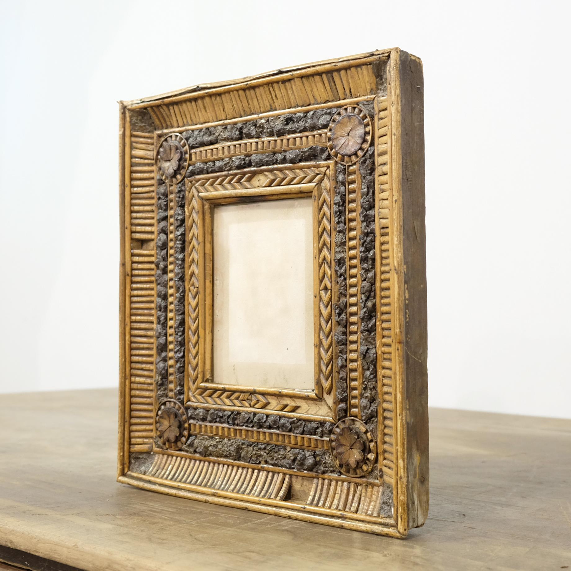 A delightfully charming and unusual 19th century Folk Art picture frame. With an extensive amount of applied intricate twig and bark decoration around a small glazed aperture. With some losses which we feel adds to its character. A great piece for a