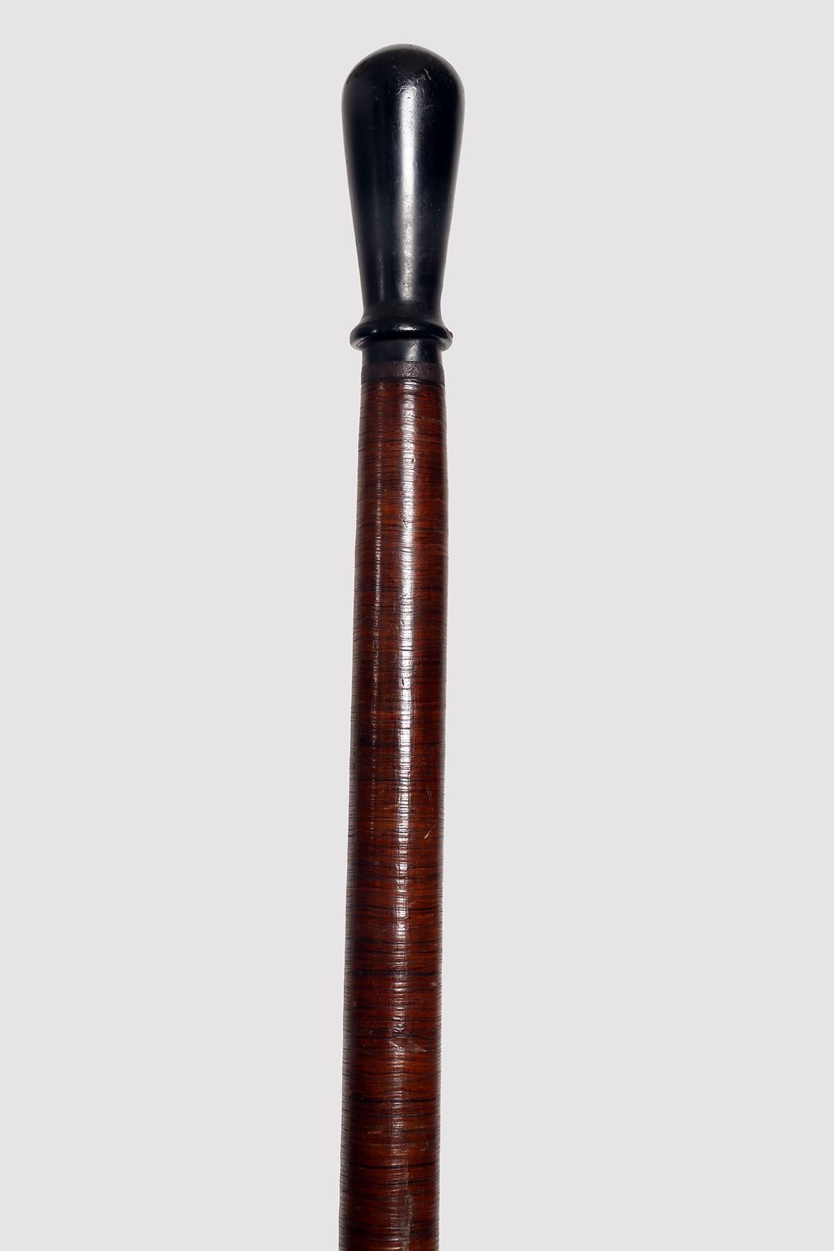 Folk art walking stick: stick with metal tip, the shaft made from an iron core in which leather discs are inserted, with a progressive diameter up to the handle. The cane is polished and waxed. The handle is connected by an iron ring, and is made of