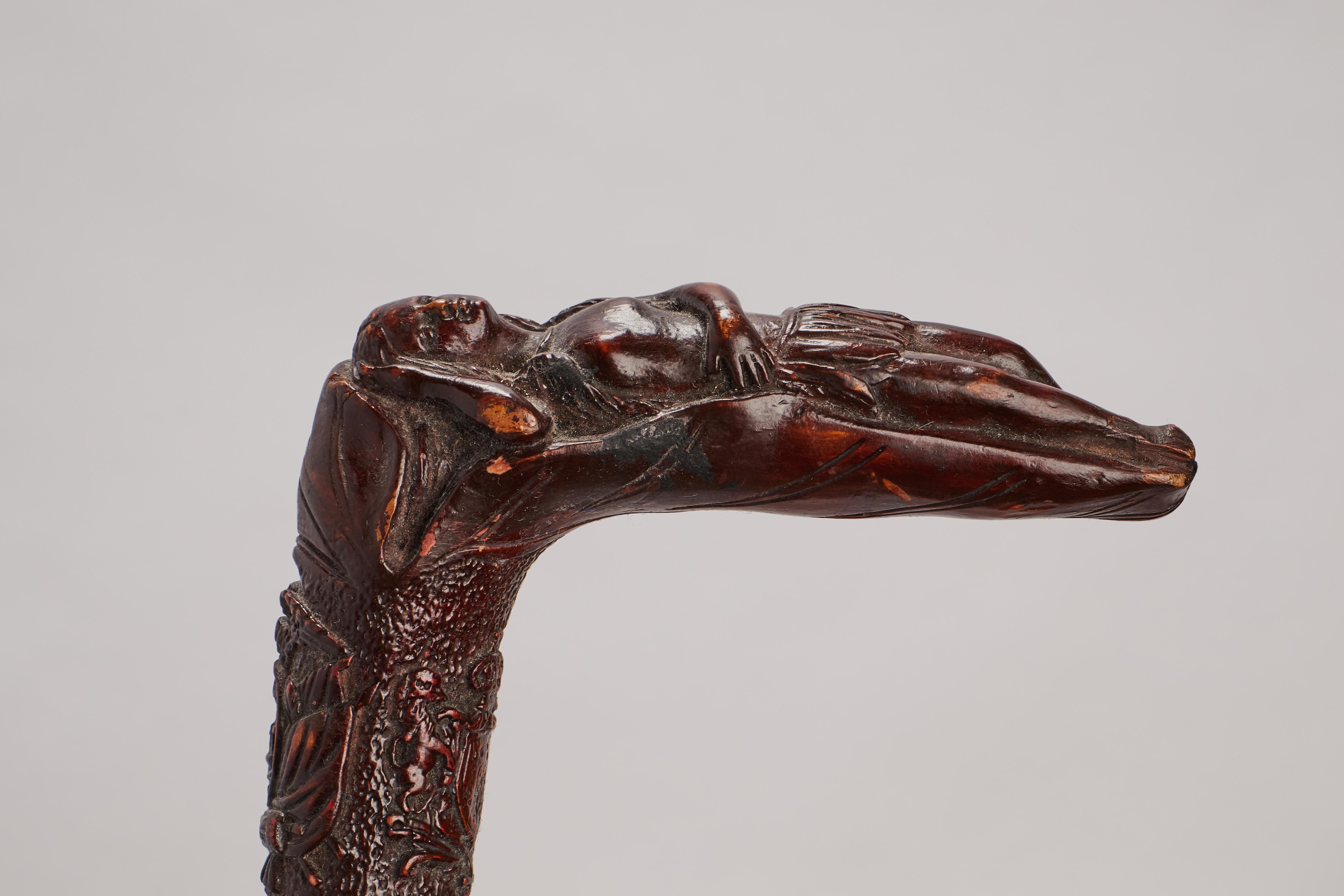 Folk art walking stick: one piece of fruitwood. The handle depicts a laying Indian woman. Engraved characters along the shaft. America XIX cent.