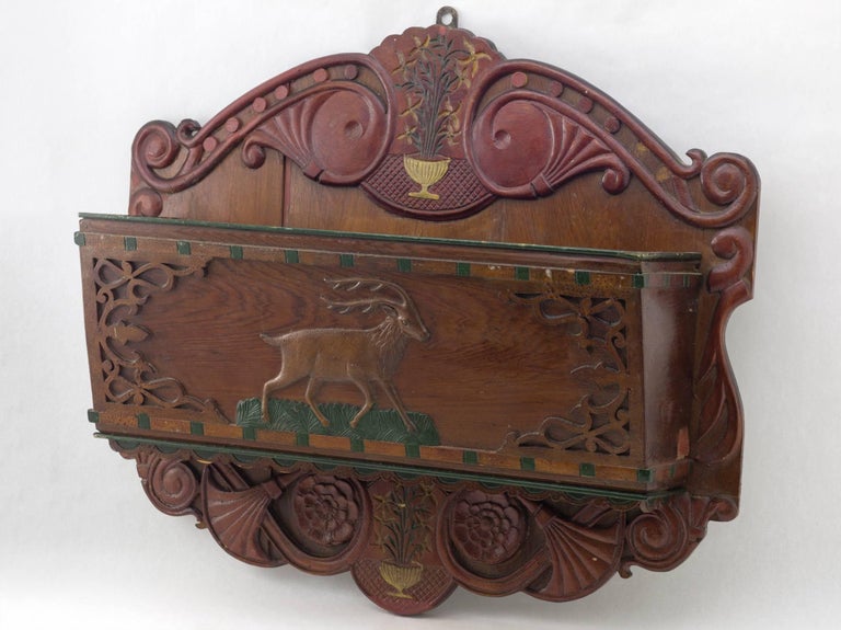 A Folk Art wooden wall pocket, polychrome 
paint with relief carved design of a deer with 
vines, urns and flowers, Virginia, circa 1870
Measures: 18” x 21” x 6”
 $1750.
 