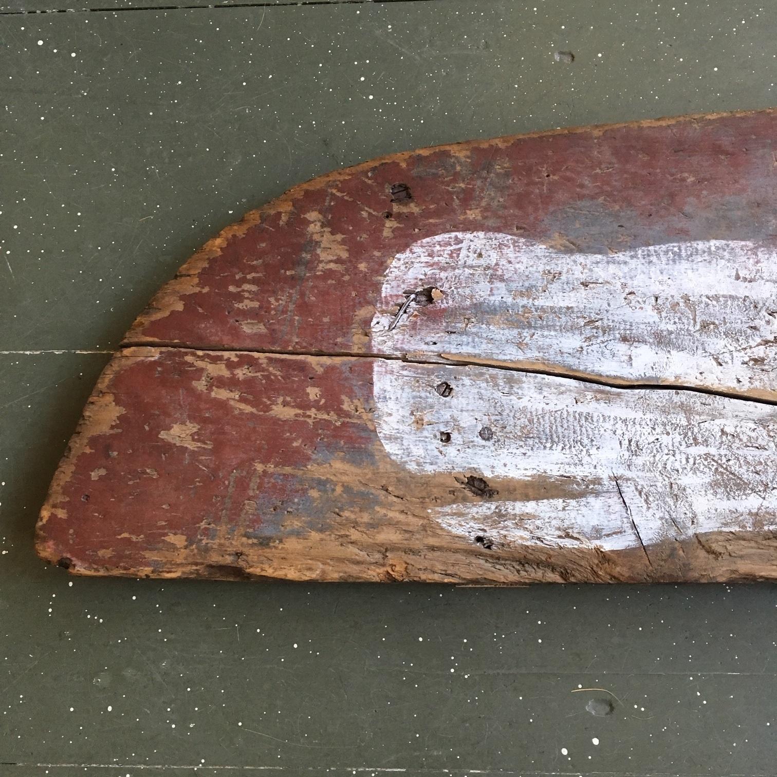 Antique Folk Art whale decorated panel from a wheel barrow. A 19th century primitive wooden side panel in original red paint, well worn, with a sperm whale painted in white wash. The whale is surely later, but appears to have very good age and has
