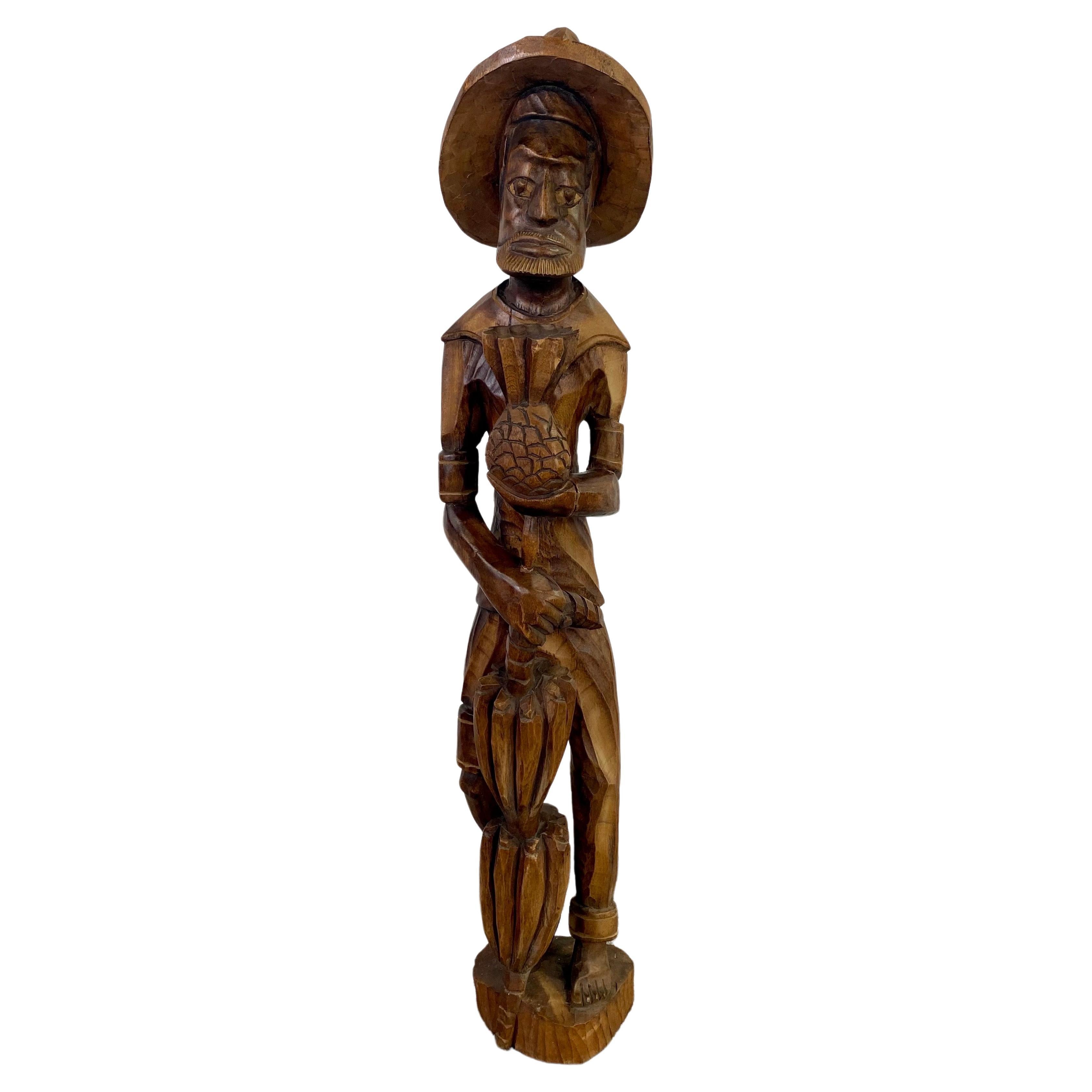 Sculpture en bois d'art populaire d'un  Homme des Caraïbes tenant un ananas 