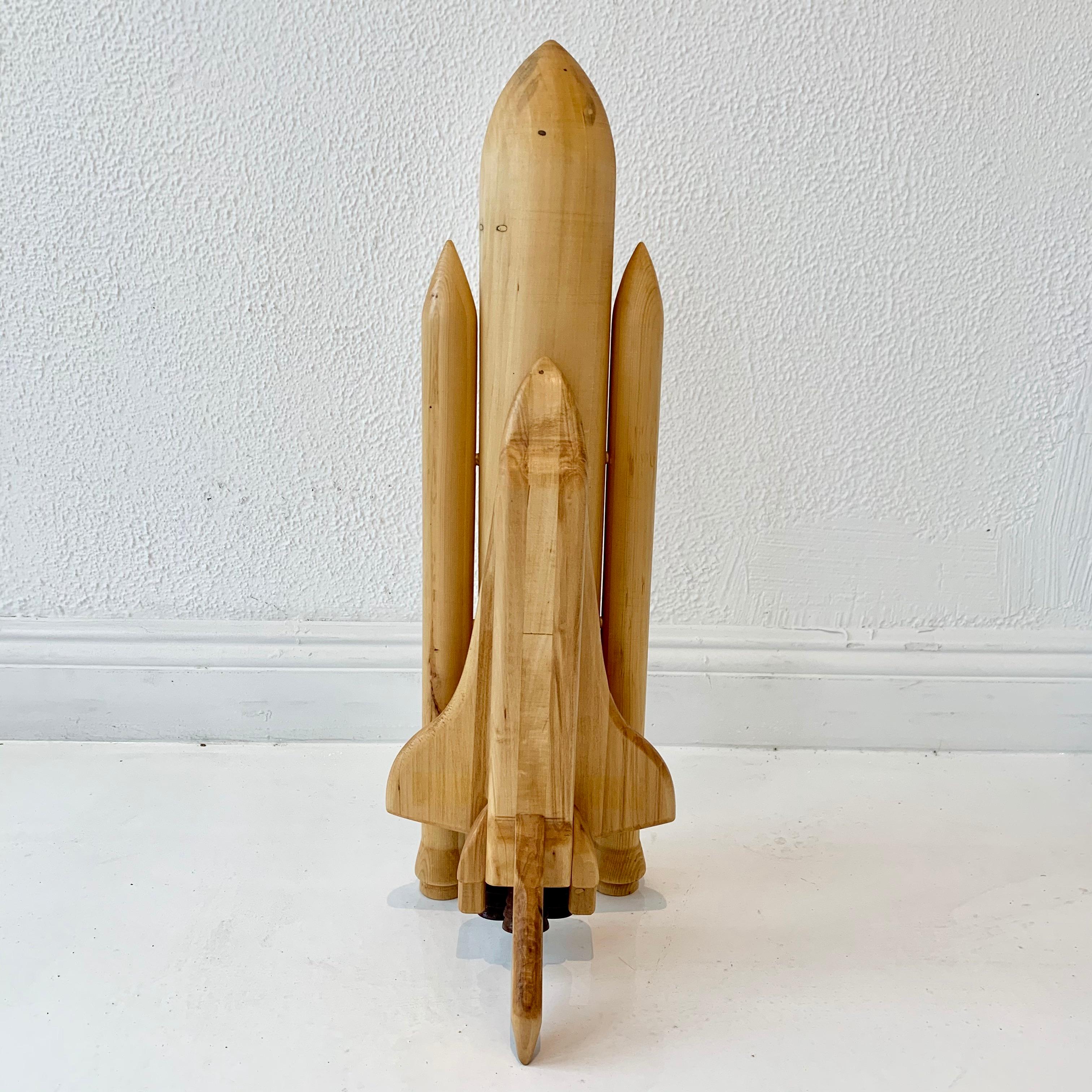 Folk Art space shuttle, hand carved in wood. 4 pieces that fit together. Main fuel tank, two rocket boosters and the orbiter/shuttle. Cool sculpture. Great condition. 

 