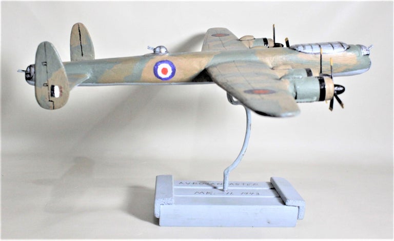 This handcrafted Folk Art model of a Lancaster Bomber is signed on the base, but the artist could not be identified so is posted as Unknown. This wooden airplane model was presumably made in Canada in approximately 1975 or later and is hand carved