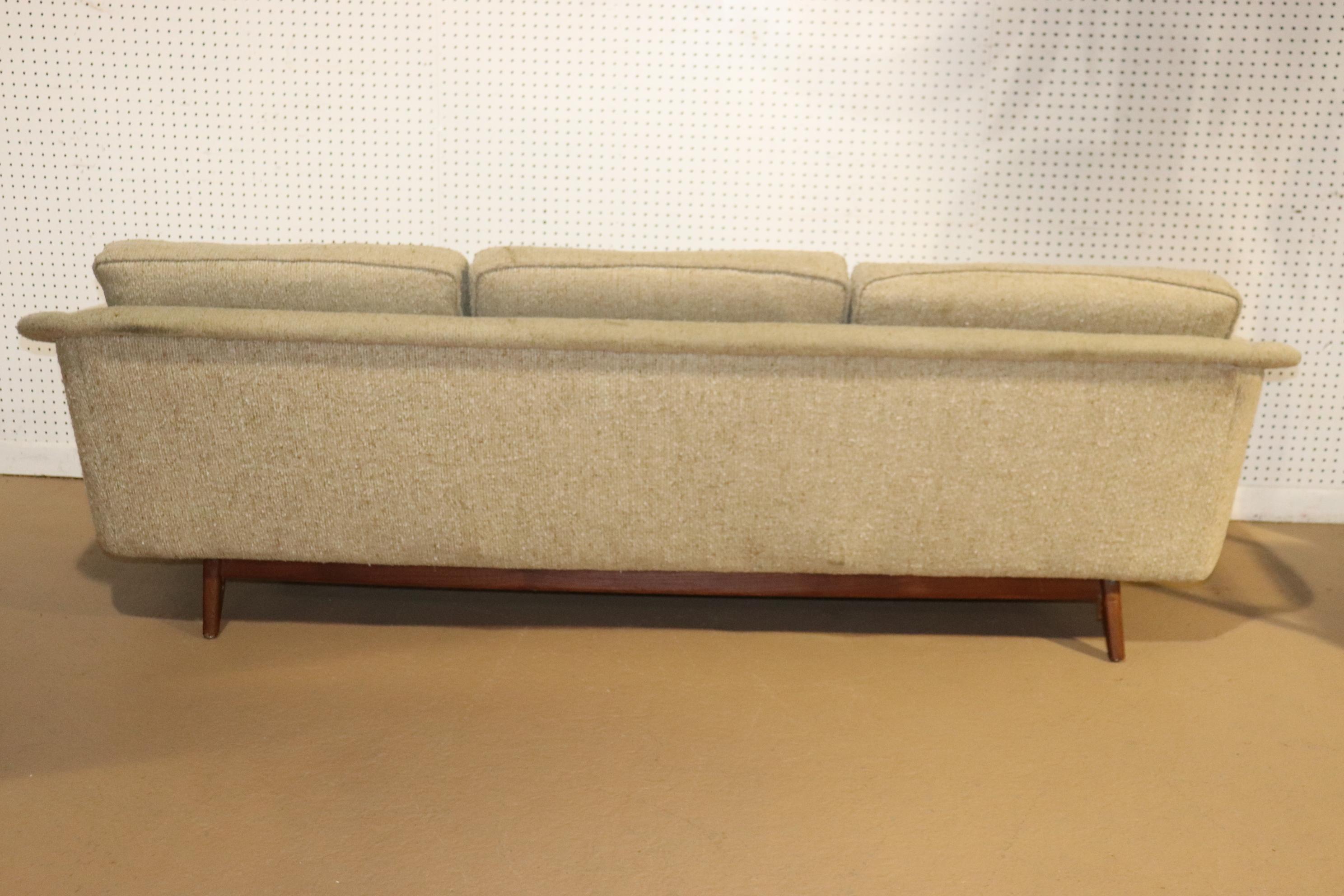 Long mid-century sofa by Folke Ohlsson for Dux with three wide seats, set on teak wood base. Attractive modern design features a slopping back that flows down to the arms.
Please confirm location NY or NJ.