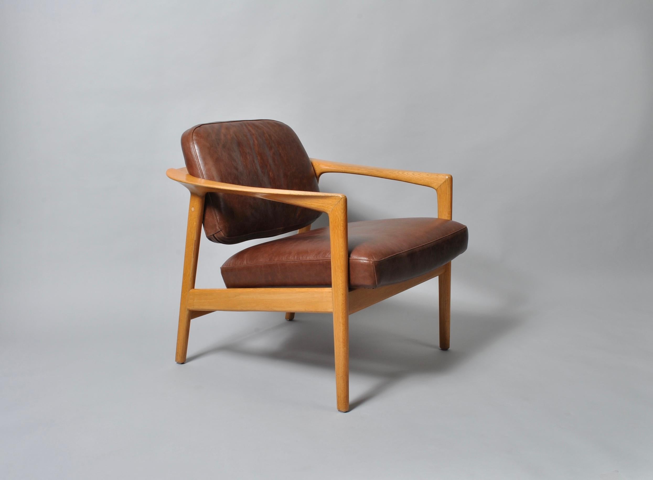 Rare midcentury Folke Ohlsson lounge chair design for DUX. Fully reupholstered by us in soft brown leather. Impressive curved and sculpted wrap arms which join the backrest around. Constructed from European white oak. Produced by DUX, Sweden in the