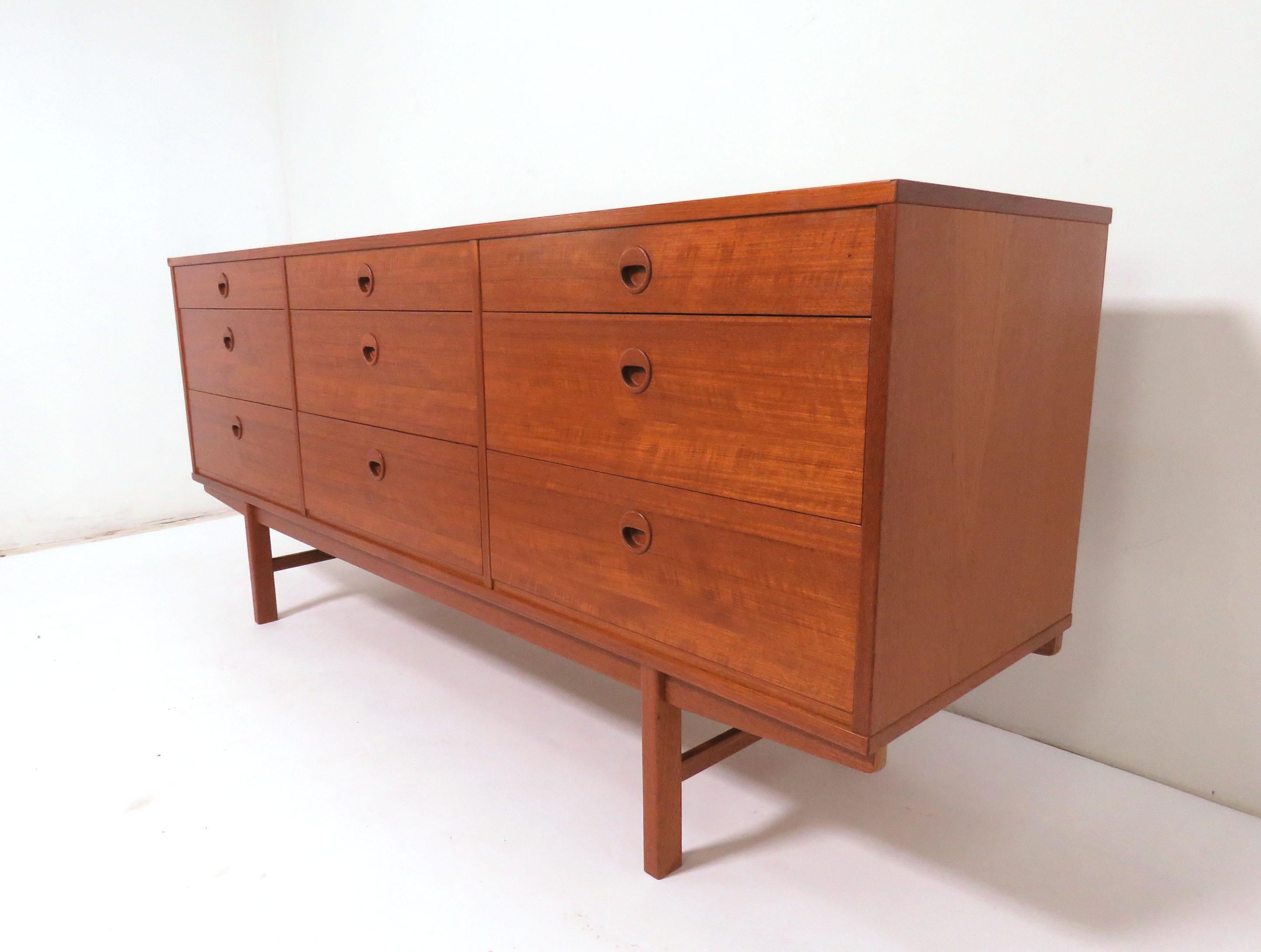 Scandinavian Modern teak buffet server / credenza with inset circular pulls by Folke Ohlsson for DUX, made in Sweden, circa early 1960s. Three shallow upper drawers at top, 3