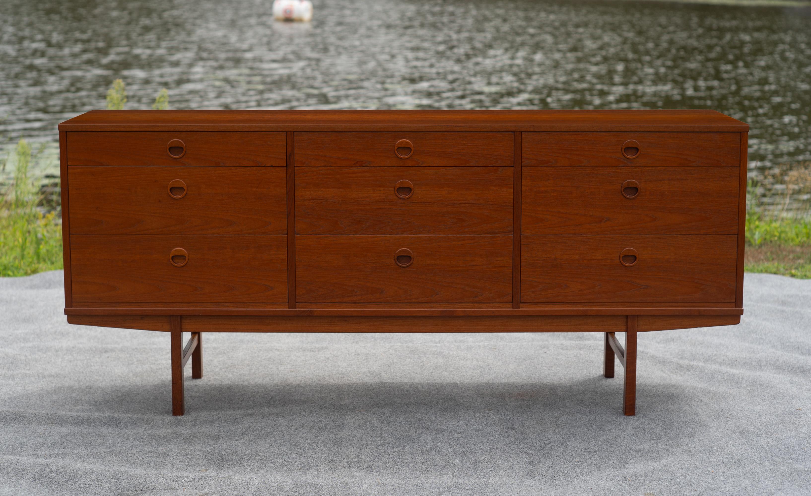 Designed by Folke Ohlsson, this dresser or sideboard was made in the 1960s by DUX of Sweden. It features teak construction throughout, with bookmatched drawerfronts, 9 large drawers, and a solid teak base. On first glance a simple design, subtle