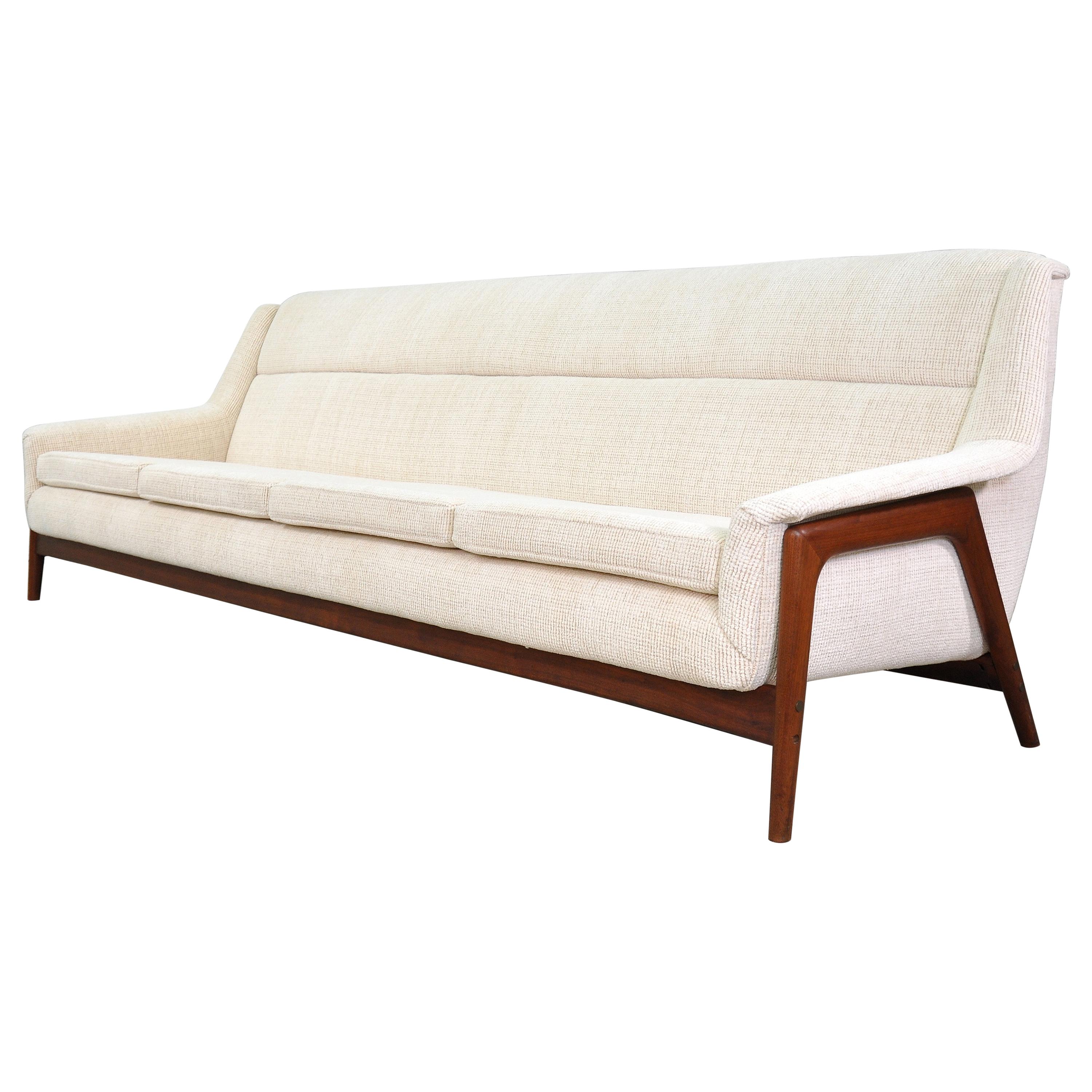 Beautiful and rarely found midcentury Scandinavian Modern four-seat couch designed in the 1960s by Folke Ohlsson for DUX. The Profil sofa feature an exposed sculptural solid teak frame. The piece has been fully reupholstered in a soft, neutral