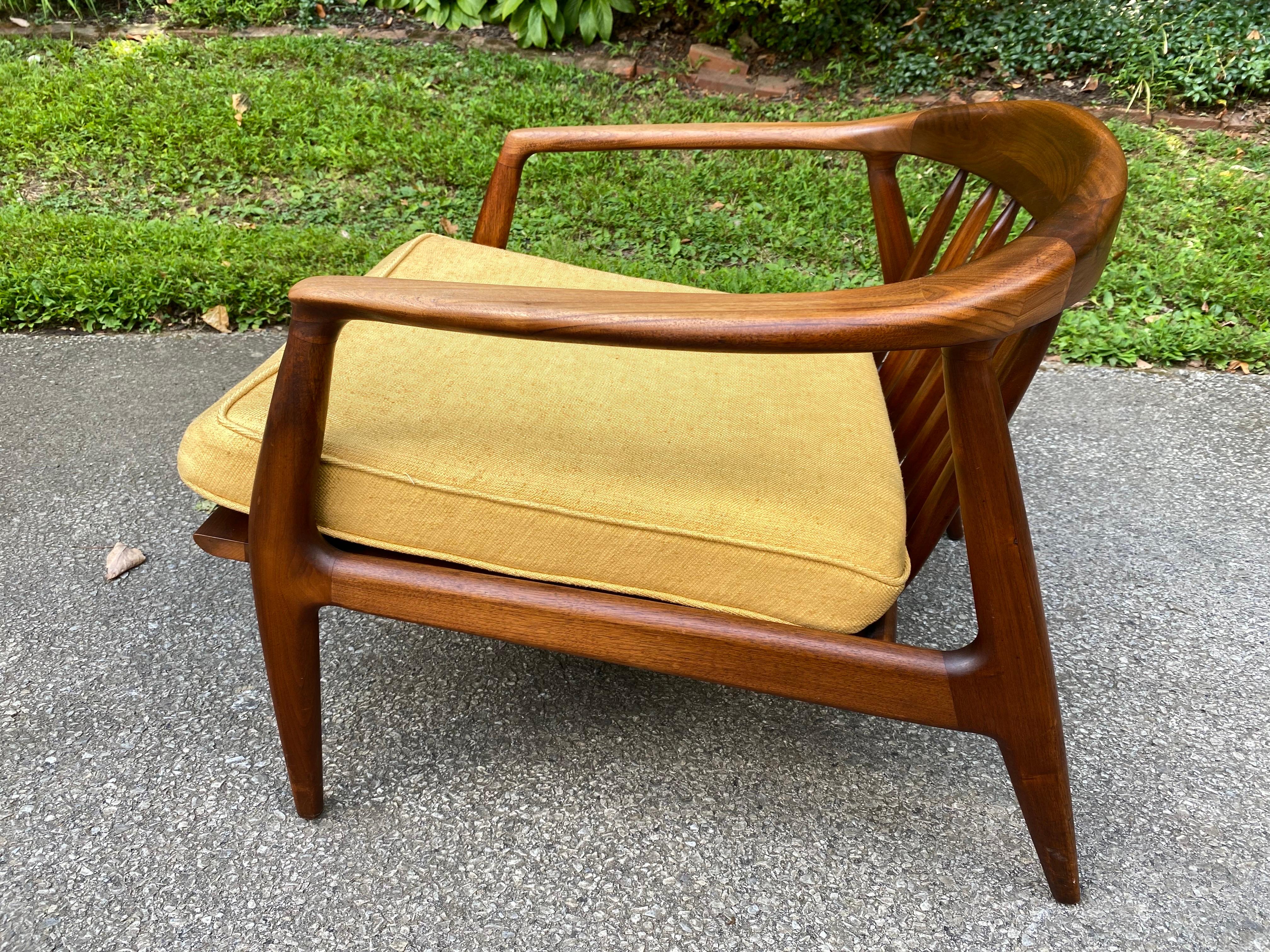 This beautiful Danish modern lounge chair designed by Folke Ohlsson for DUX is a perfect complement to a formal living or casual family room for reading or watching TV. The frame is made of dark teak that subtly curves along the back and the