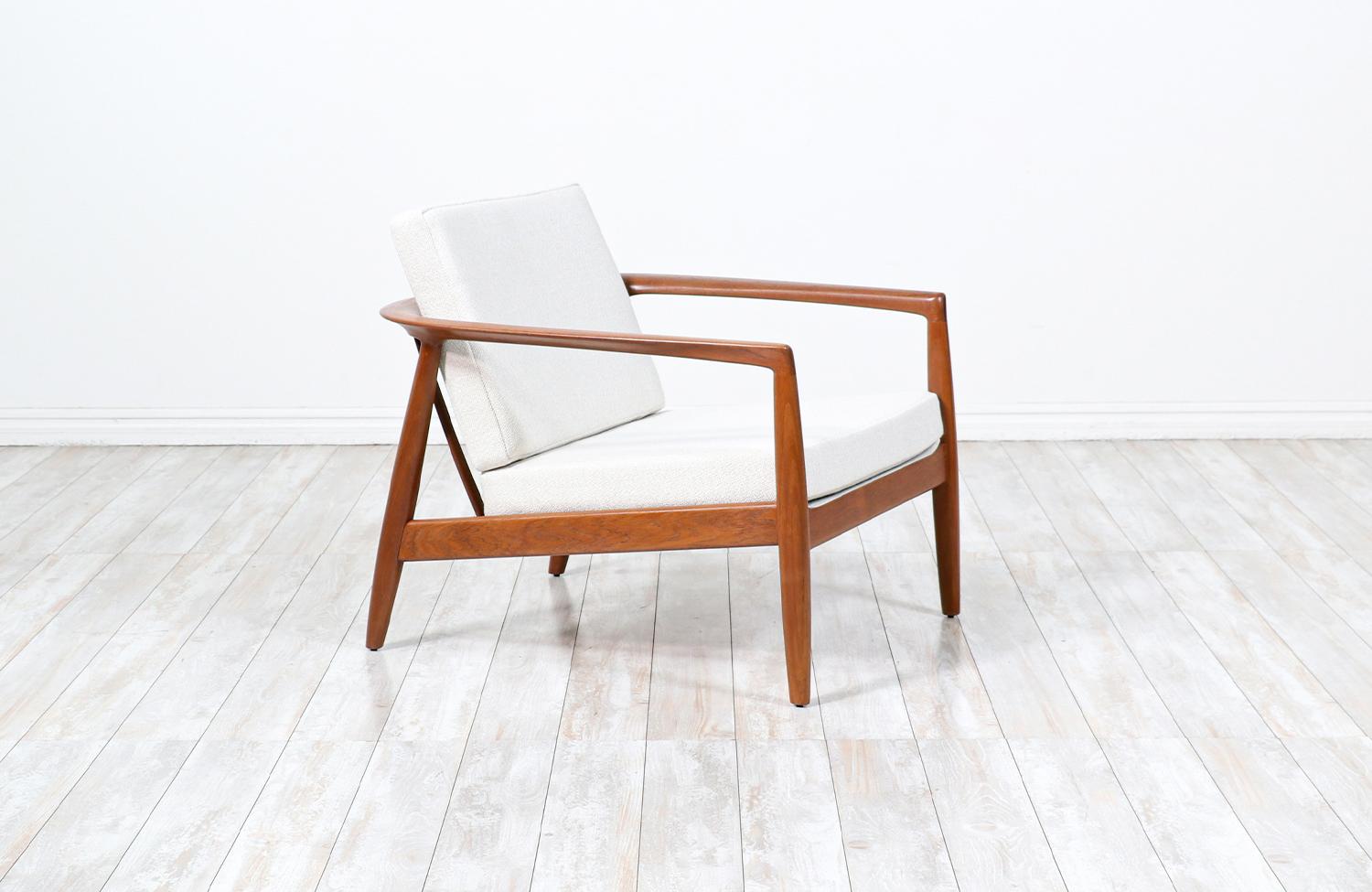 Elegant modern Model 72-C lounge chair designed by Folke Ohlsson for Dux of Sweden circa 1950s. This sturdily constructed lounge chair features a solid teak wood frame with eight vertical slats in the open back that add support while giving it a