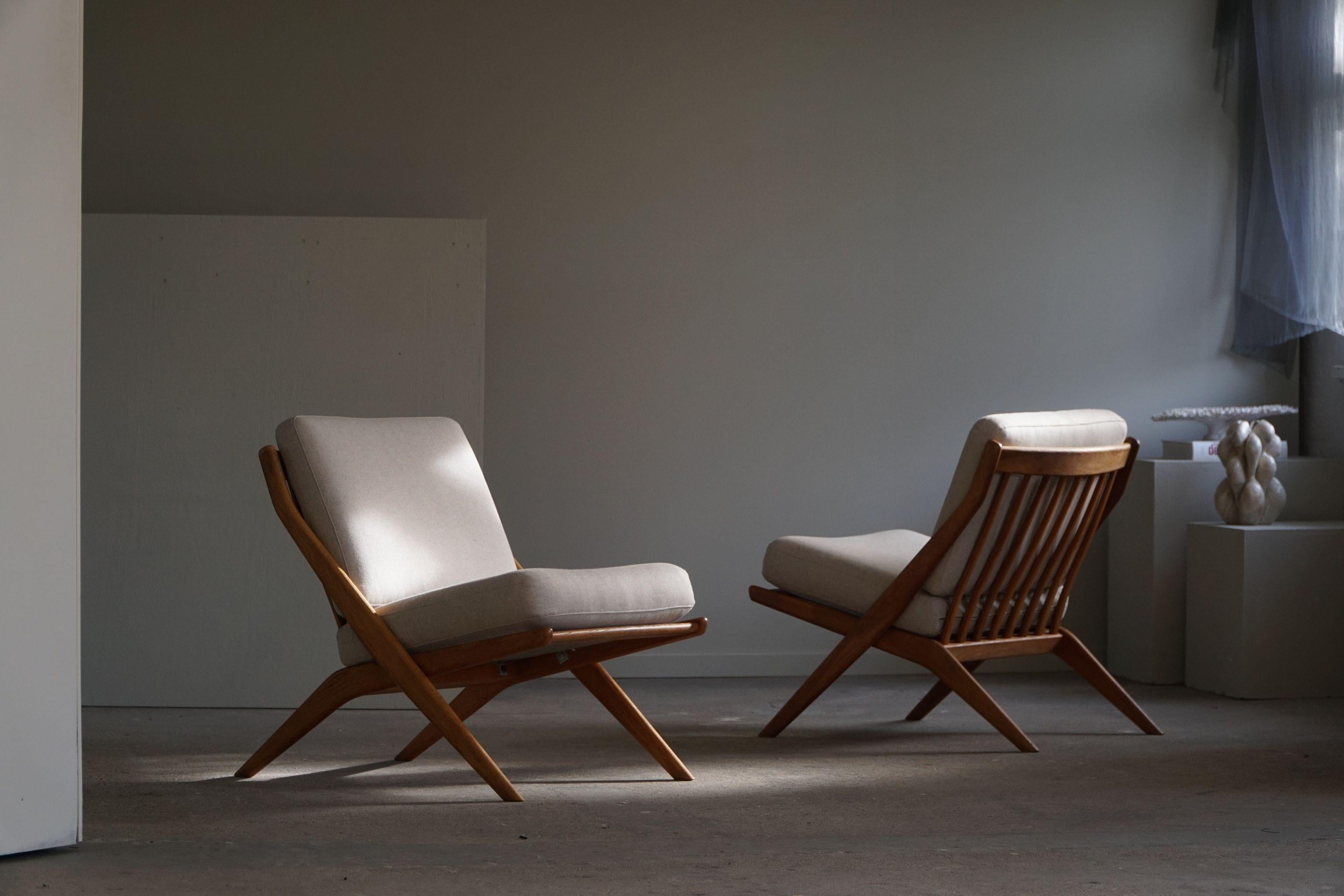An elegant pair of mid century modern lounge chairs in oak, cushions reupholstered in high quality grey wool. Designed by Folke Ohlsson for the Swedish company AB Svenska Möbelfabrikerna Bodafors in 1961. Model 