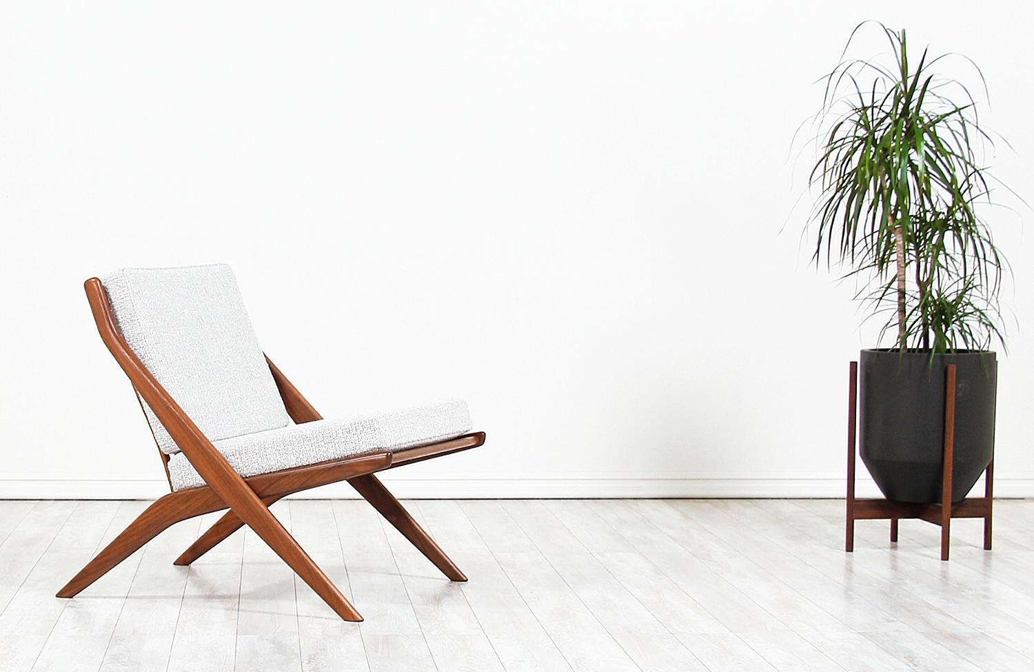 Elegant modern lounge chair designed in Sweden by Folke Ohlsson for DUX of Sweden, circa 1950s. This Minimalist lounge chair features a solid walnut wood frame with new high-density foam cushions and light-colored tweed fabric upholstery. This