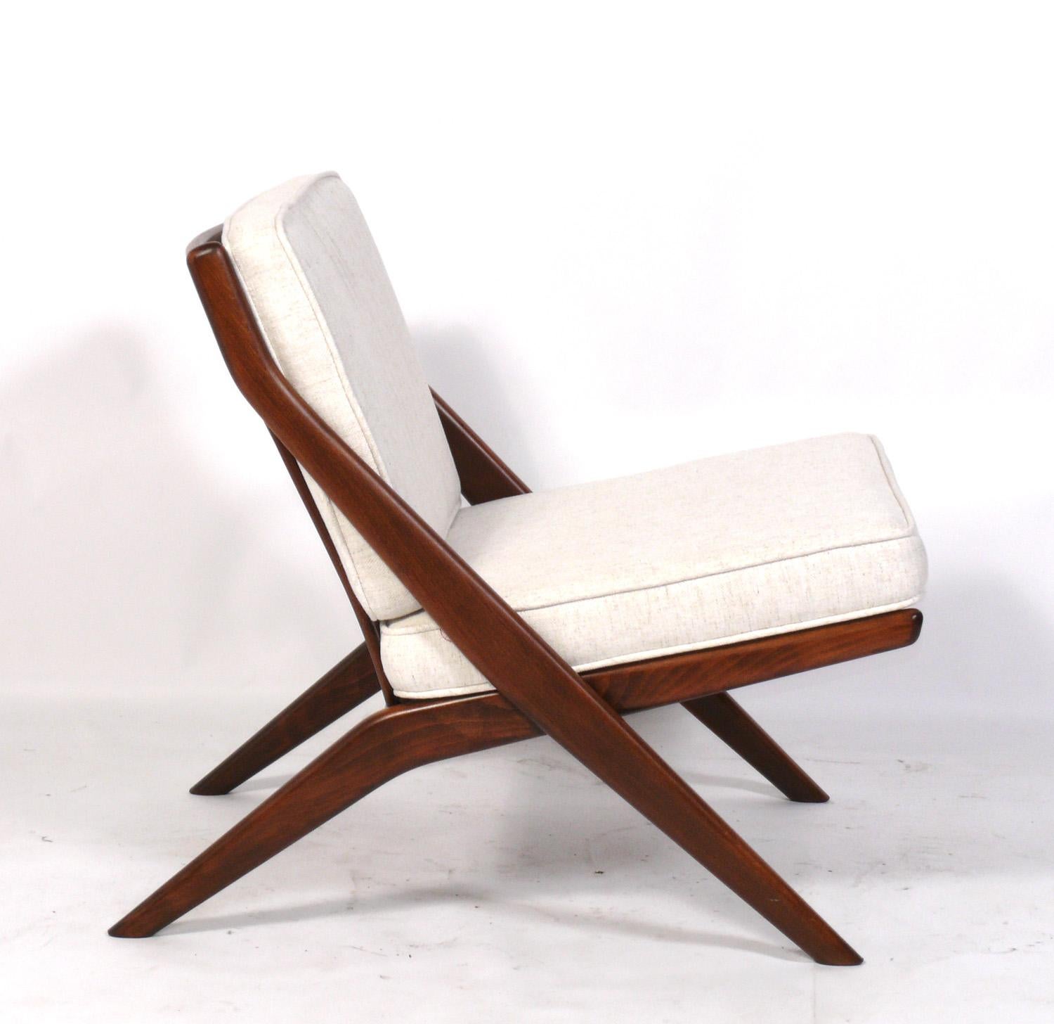 Sculptural Danish Modern style Scissor lounge chair, designed by Folke Ohlsson for Dux, Sweden, circa 1960s. The teak frame has been cleaned and Danish oiled and the cushions have been reupholstered in an ivory color herringbone fabric.