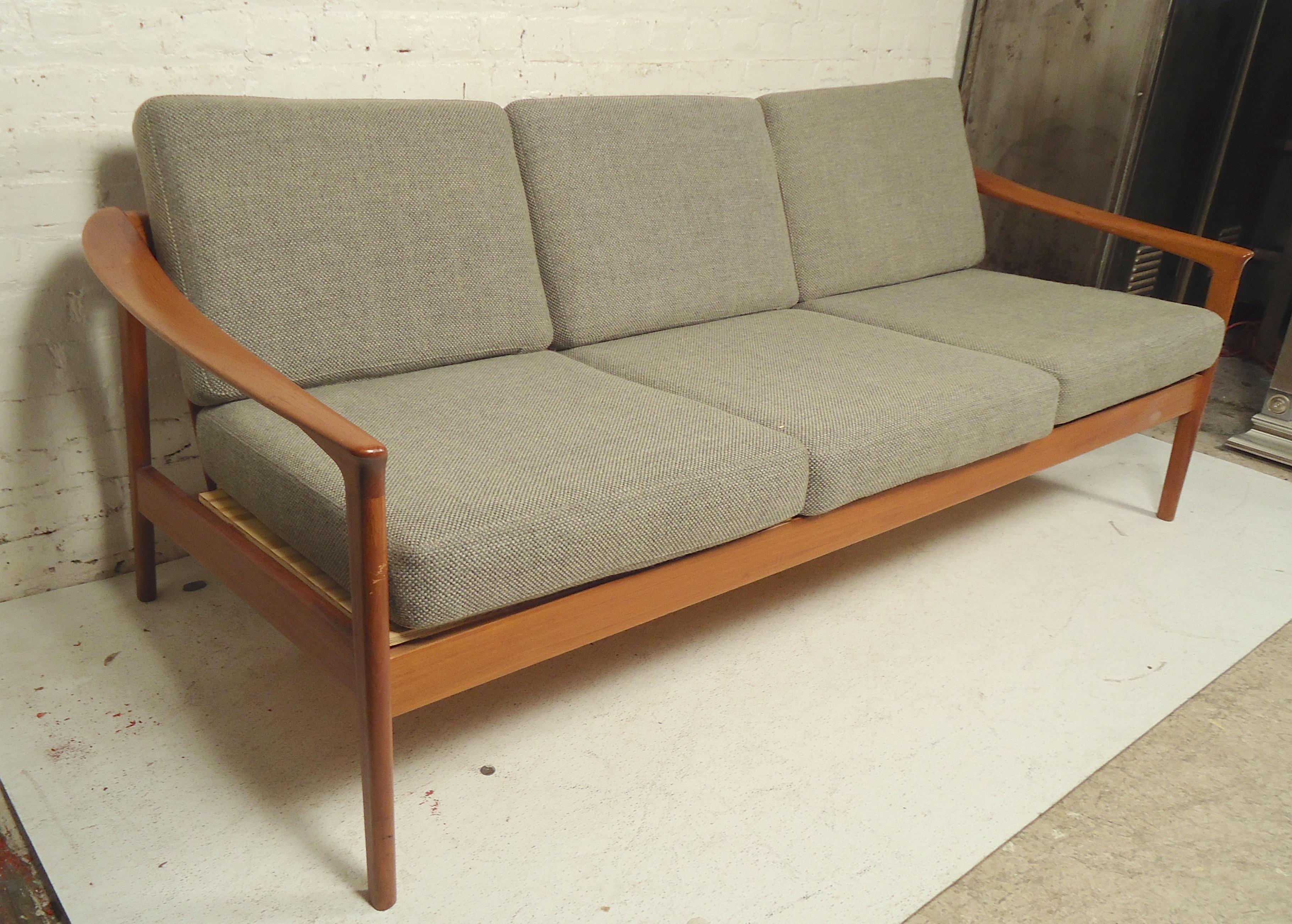 Beautiful teak wood sofa by Folke Ohlsson. Slatted back and sculpted arms with three seats.

(Please confirm item location, NY or NJ-with dealer).
 